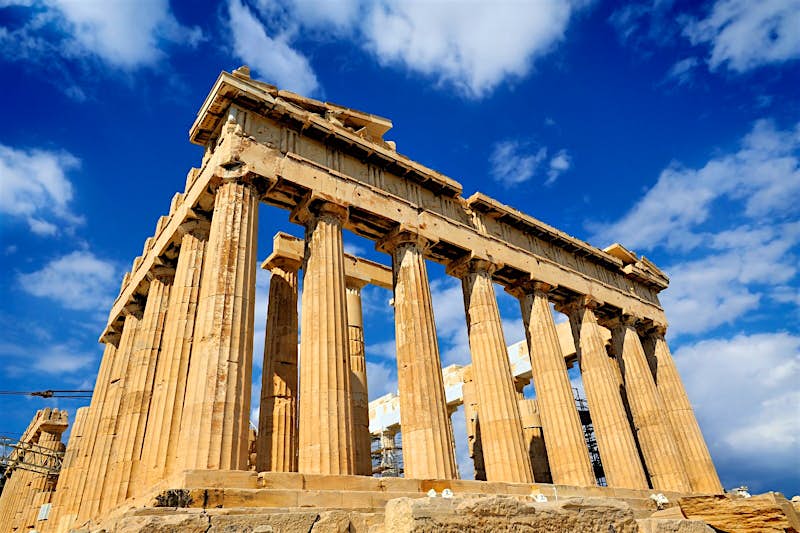 A close view of the fluted Doric columns of the Parthenon temple on a sunny day in Athens, Greece.