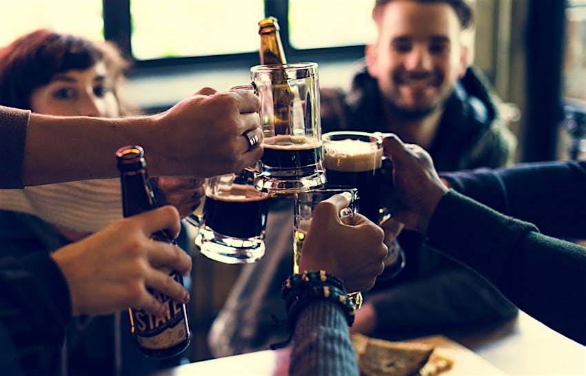 Features - shutterstockRF_567313987-e2c44424bb6e A group of friends toast their beers in a bar