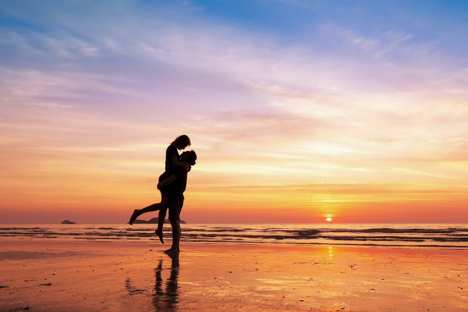 Travel predictions for 2018 - A silhouetted couple embrace on the beach at sunset © NicoElNino / Shutterstock