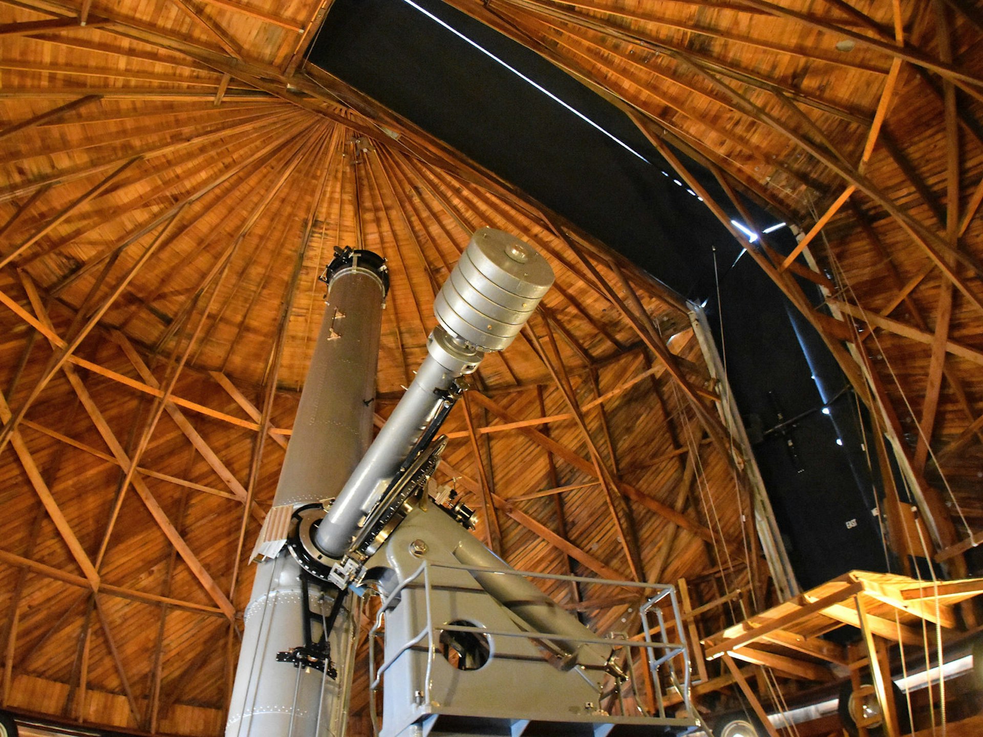 A large telescope points through an observatory into the night sky; Stargazing Southwest USA