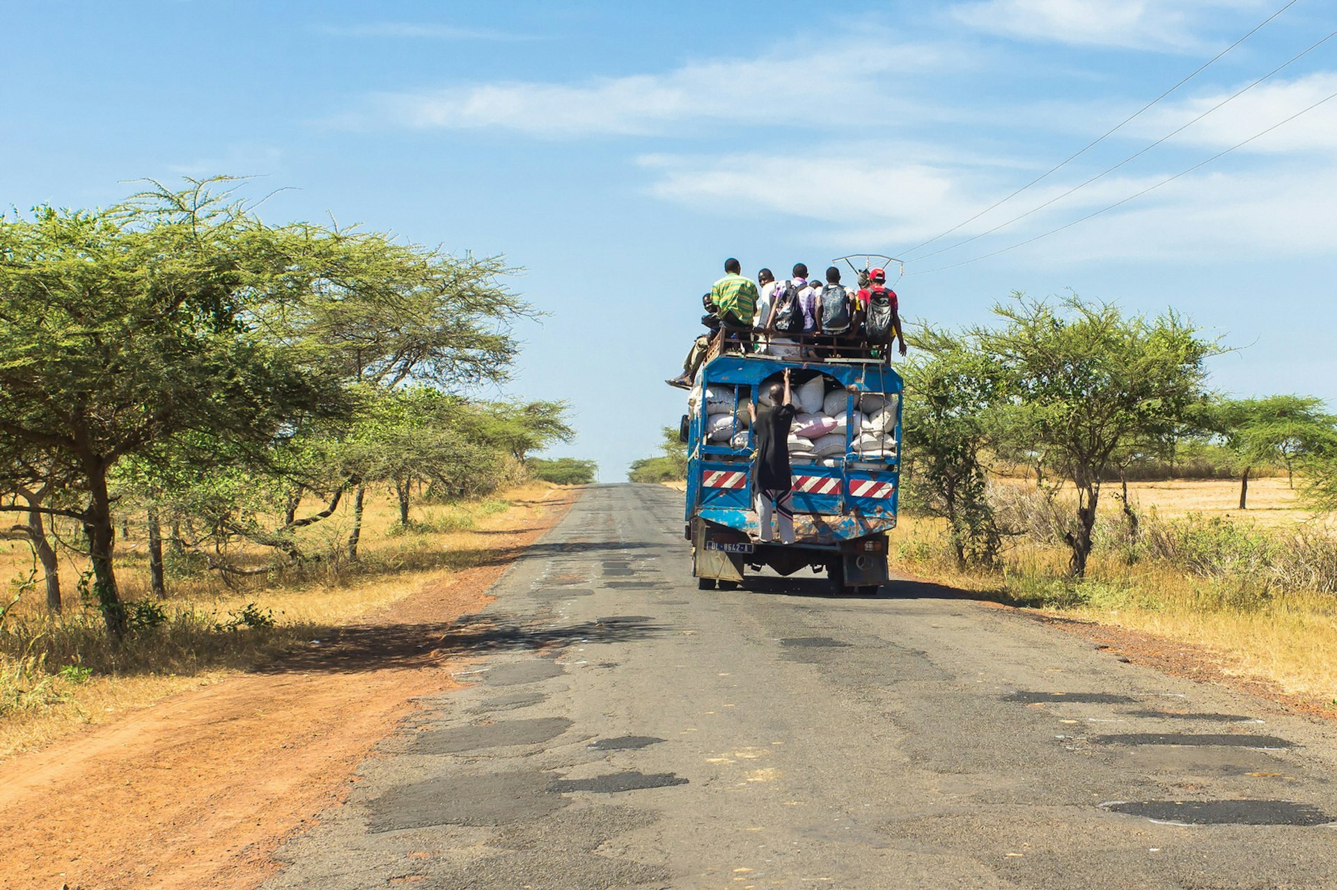 An overcrowded bus travels down a road in Senegal 