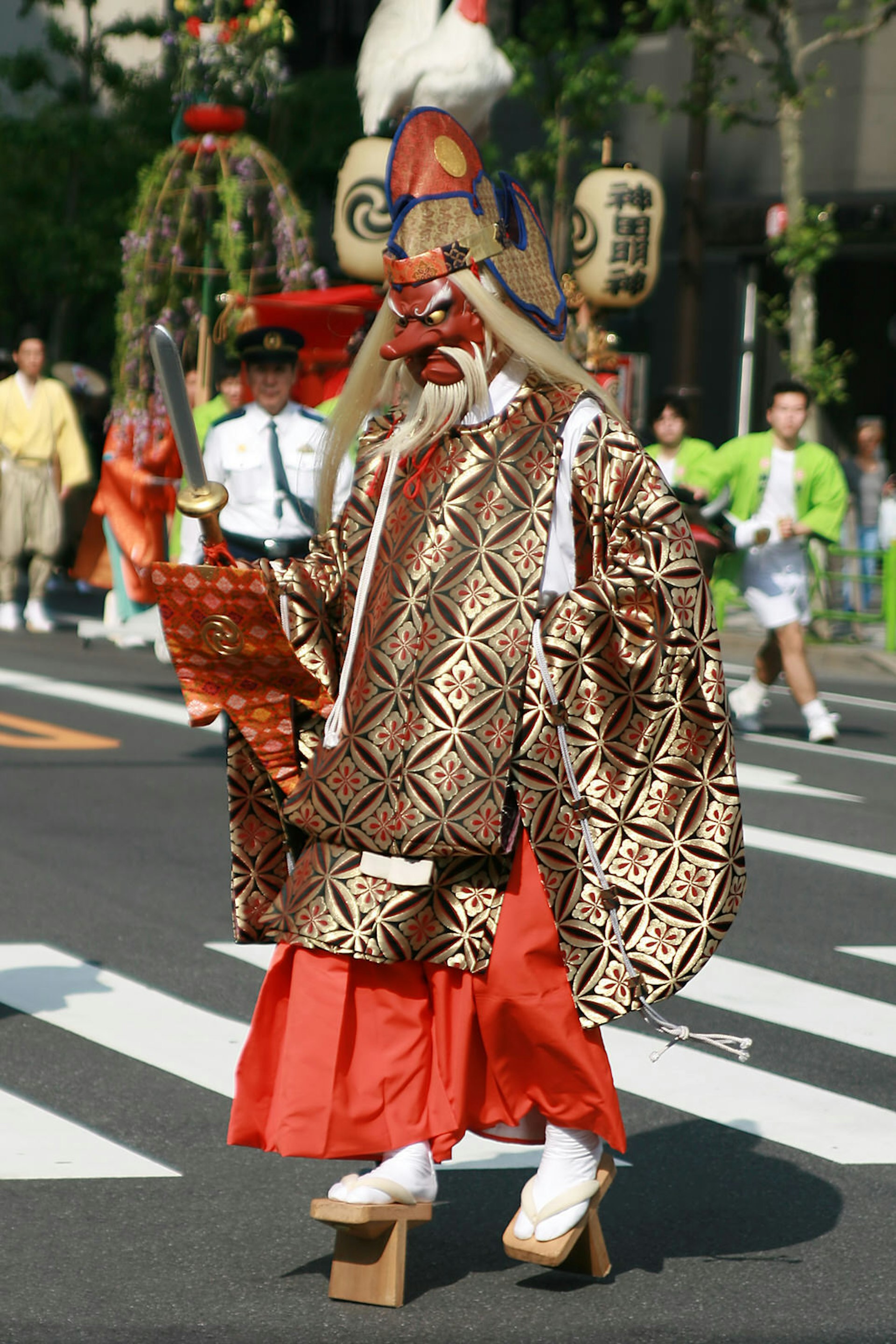 A person dressed in an elaboarate Tengū costume and mask walking across a street in Japan