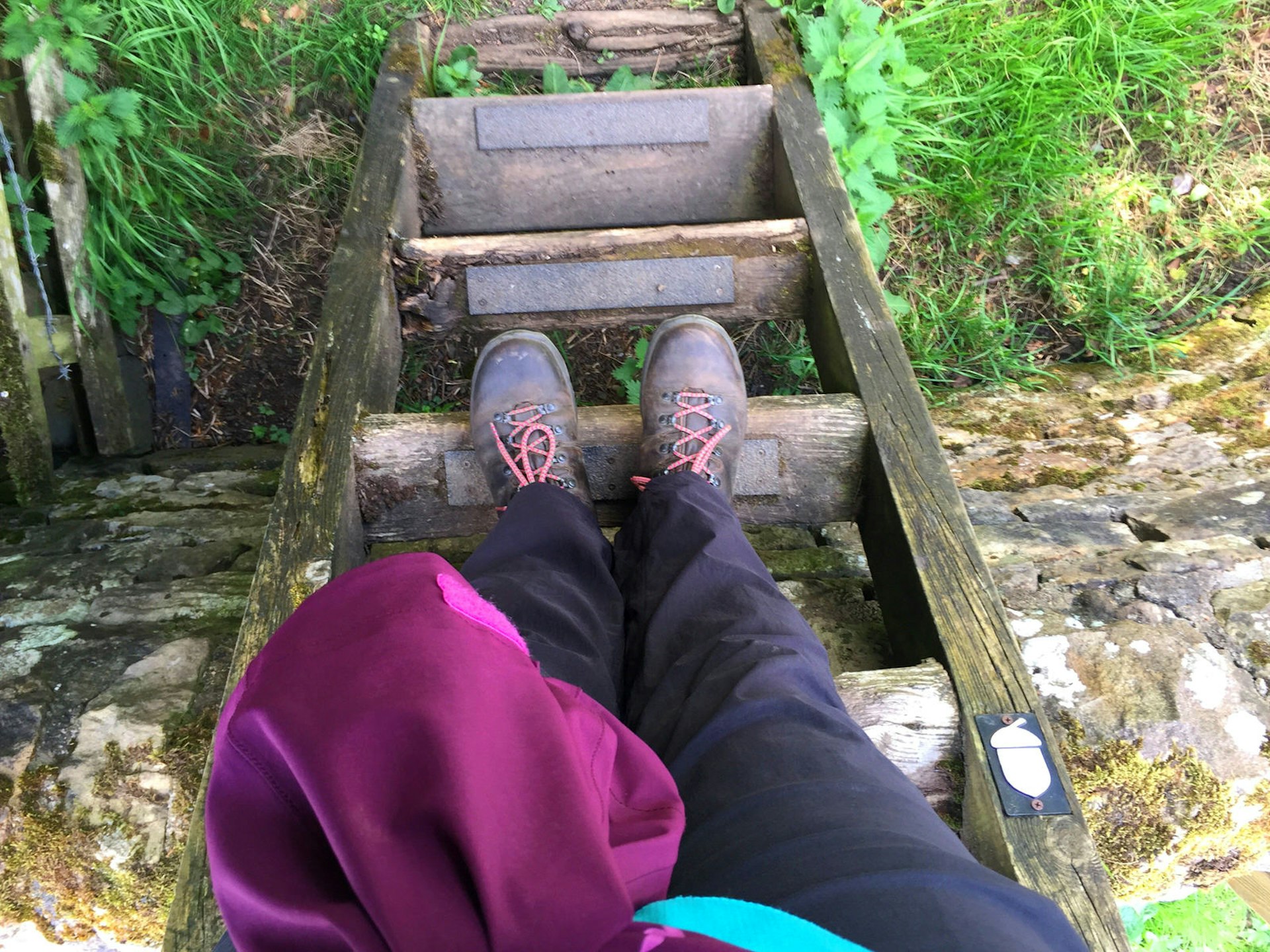 View of a walker's legs and boots standing on stile steps