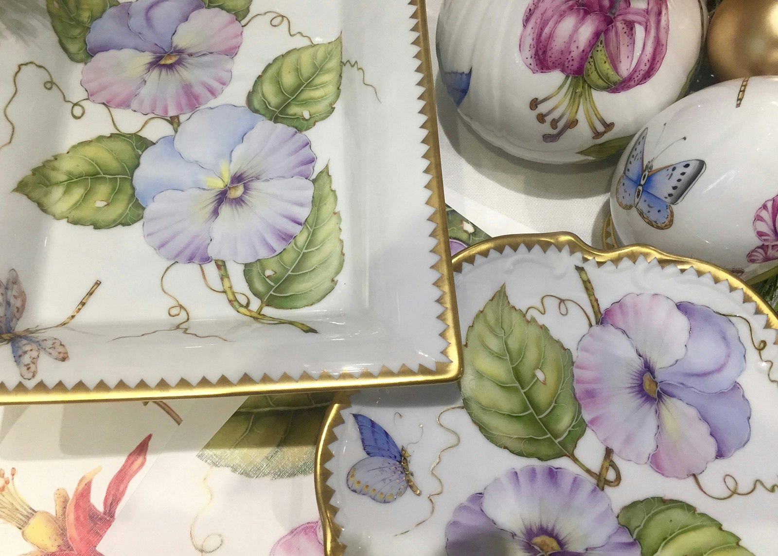 close-up of pansies on china dishes with gold edging