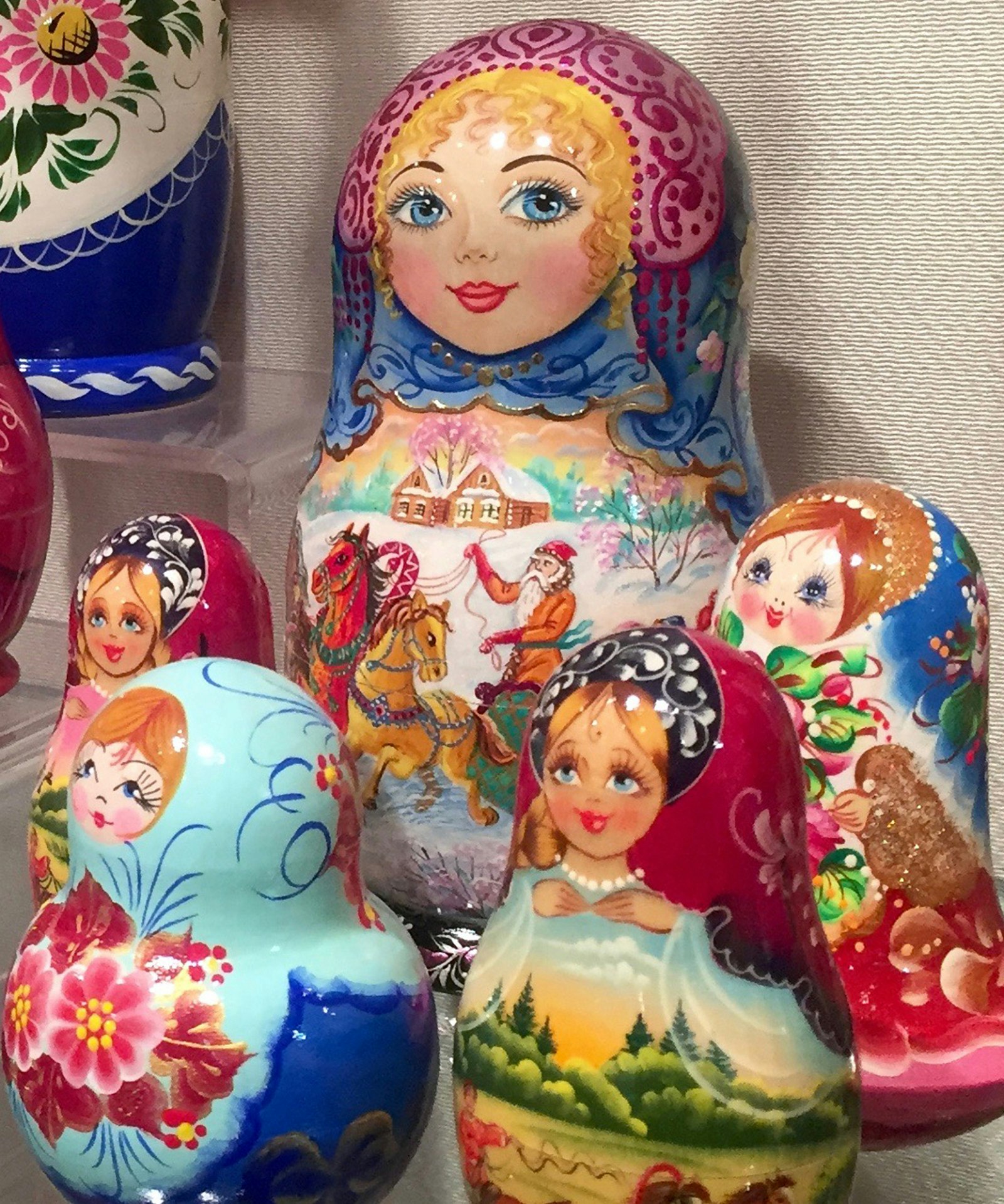bright nesting dolls of various sizes for sale in a museum shop