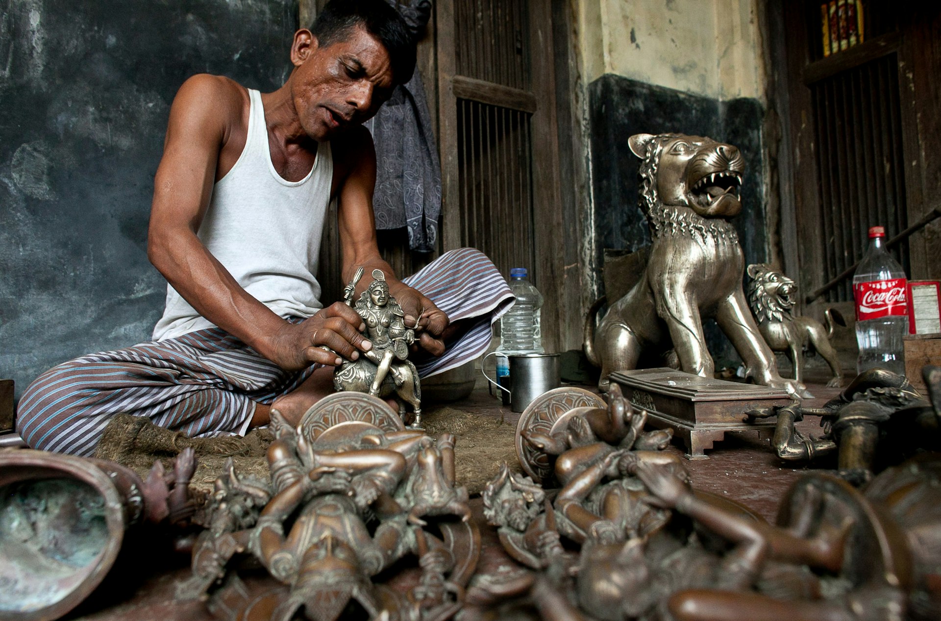 Metal worker creating religious statues via the ancient lost wax process in Dhamrai 