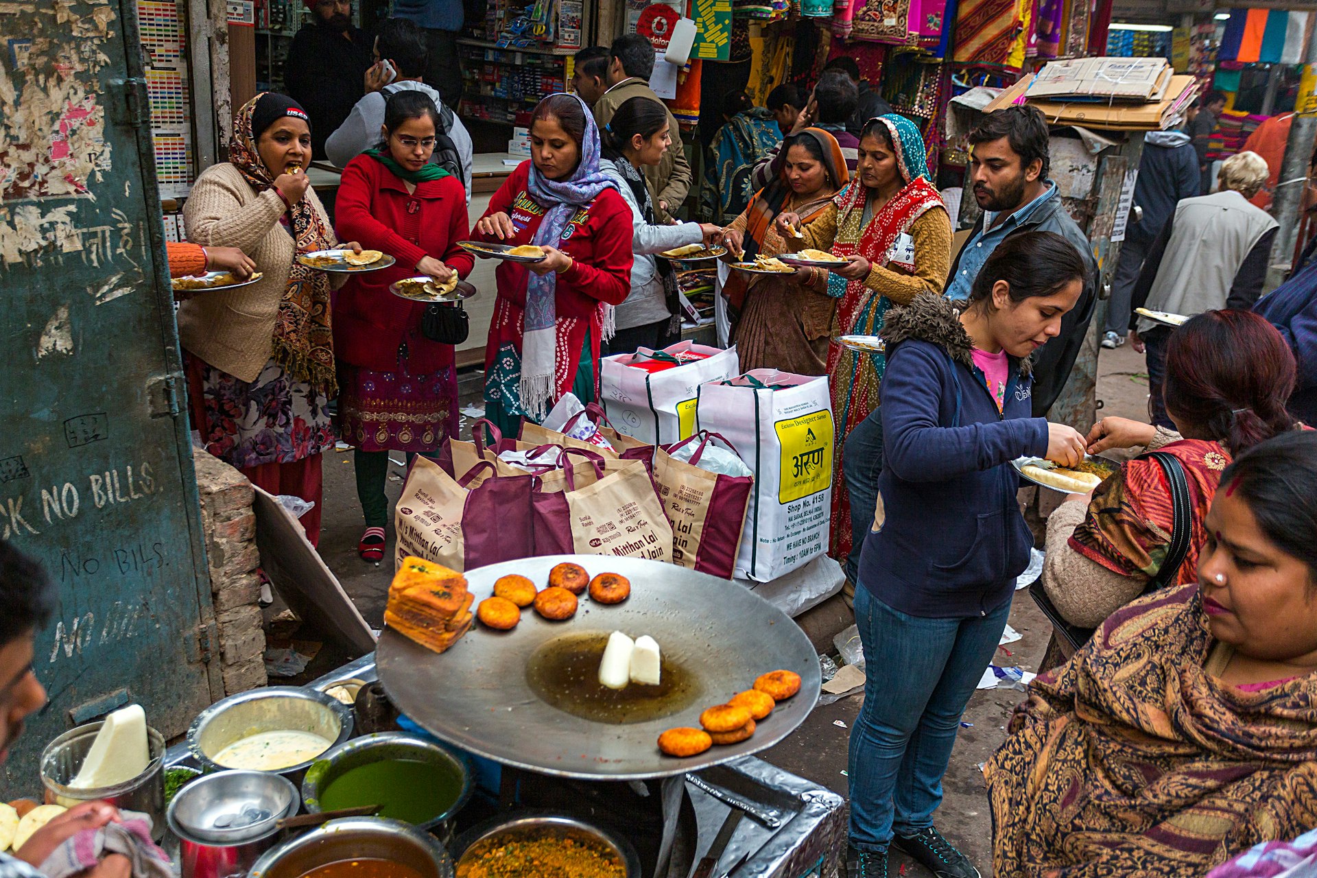 Women gather in a Delhi market for a street food snack