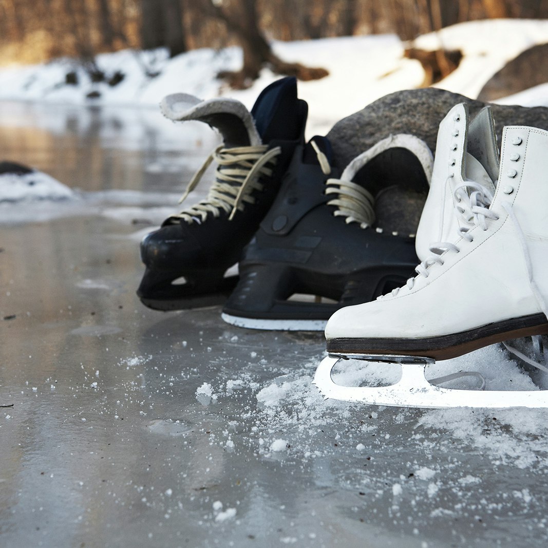 hockey skates and figure skates together on a frozen pond in winter in Minneapolis
