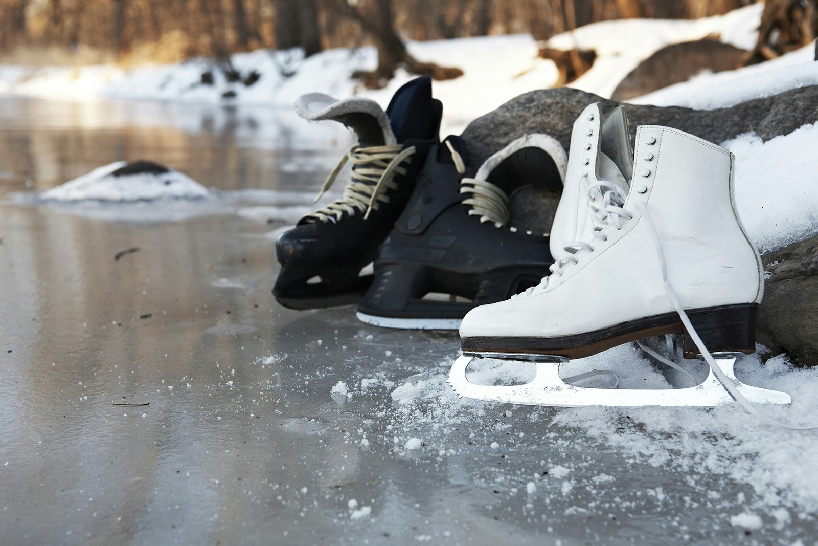Hockey skates and figure skates together on a frozen pond in winter in Minneapolis 