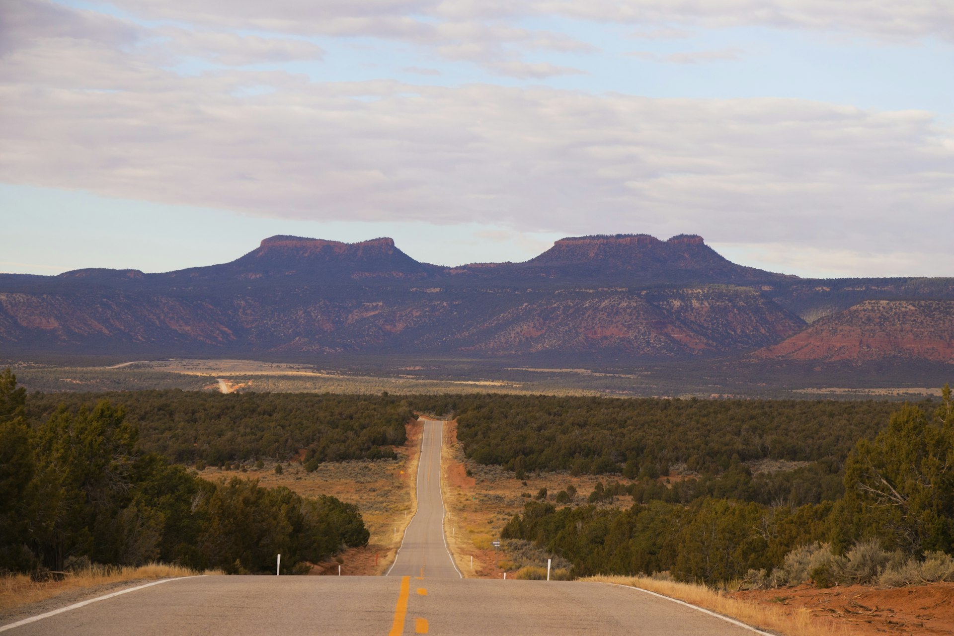 A long. straight highway runs between the twin buttes known as Bears Ears which gave its name to the National Monument