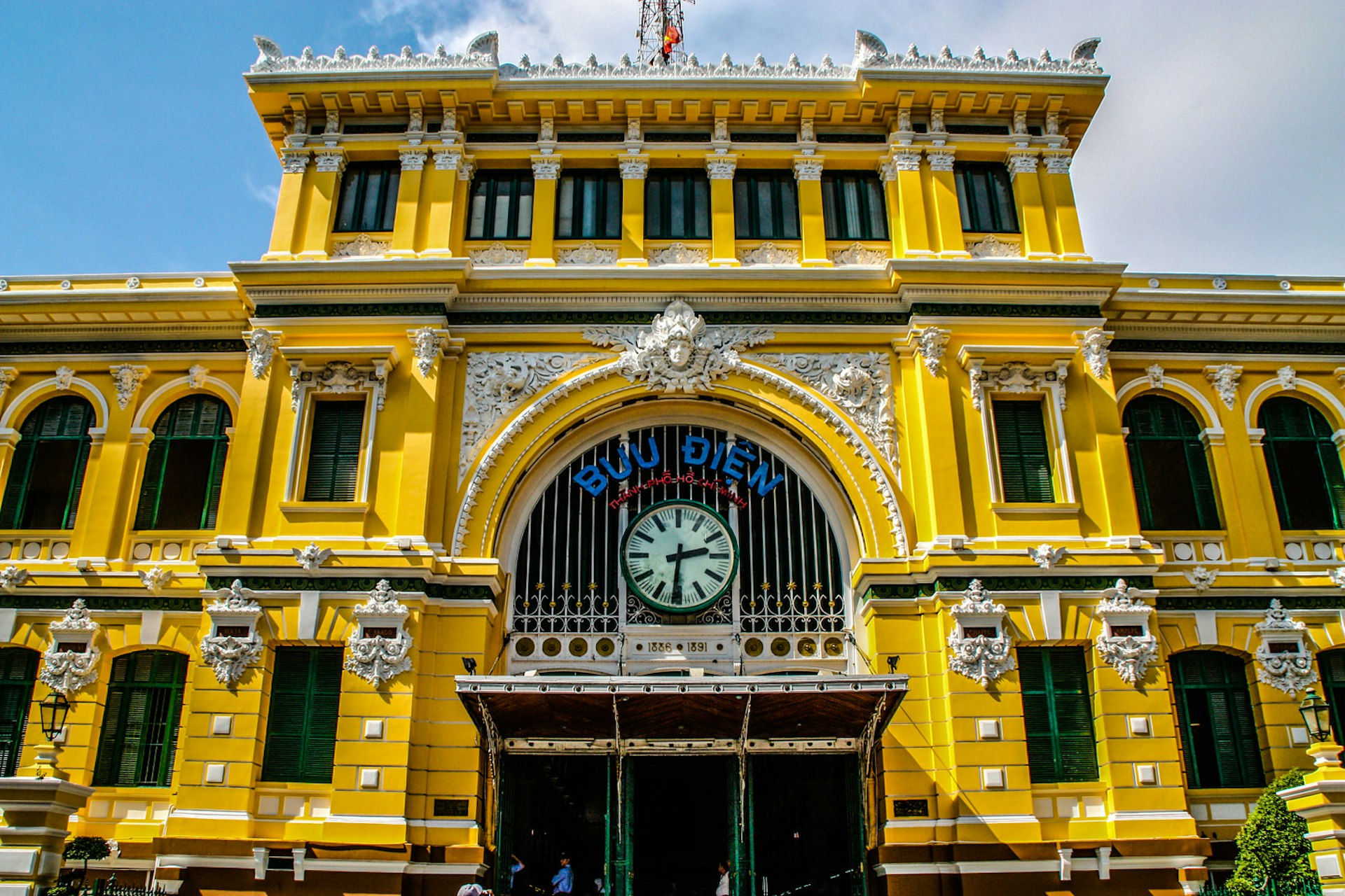View of the yellow, ornate facade of the central post office building in Ho Chi Minh City
