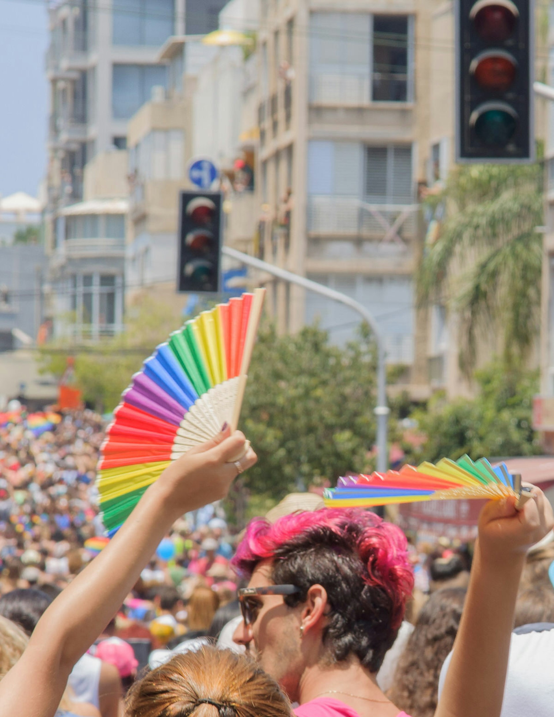 A crowd of people march in the Pride Parade in the streets of Tel Aviv, Israel. The pride parade is an annual event of the gay community. Image by RnDmS / Shutterstock