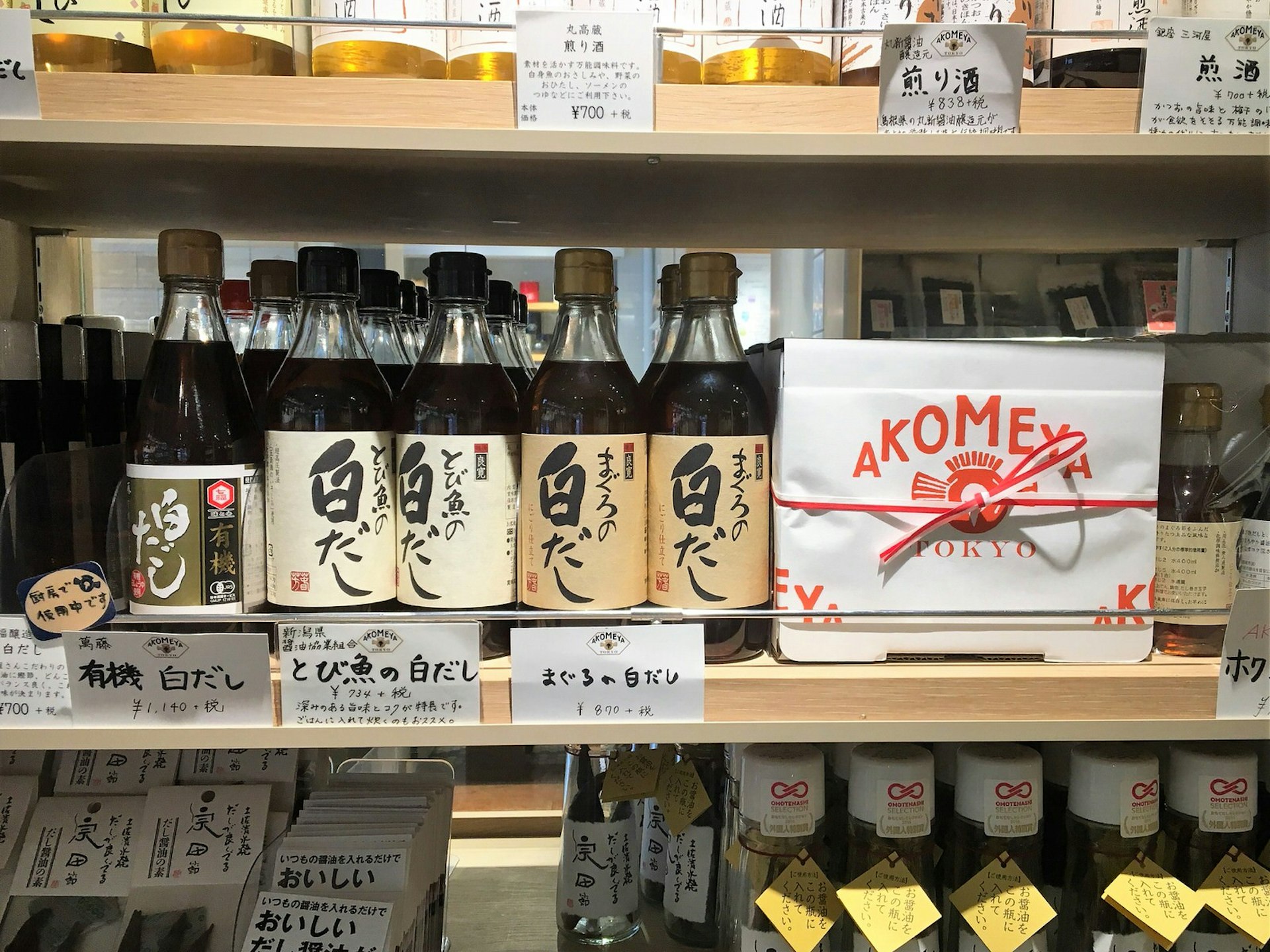 A shelf lined withi bottles of soy sauce and a gift box of sauces with the Akomeya logo © Rebecca Milner / Lonely Planet