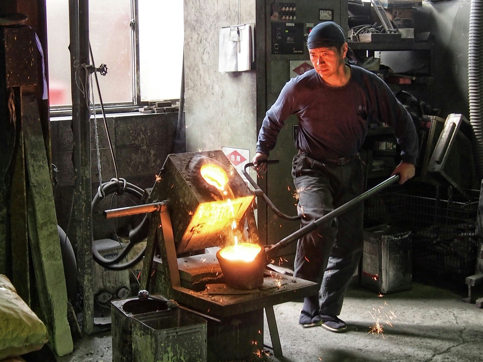 An ironware worker pours molten iron into a mold in the Iwachu workshop © Manami Okazaki / Lonely Planet
