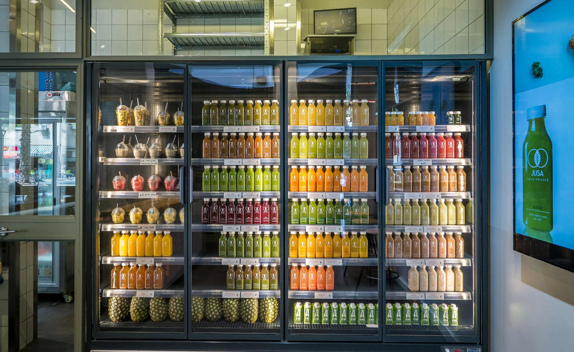 Refrigerated shelves of juices available at Jusa in Tel Aviv. Image by Jusa