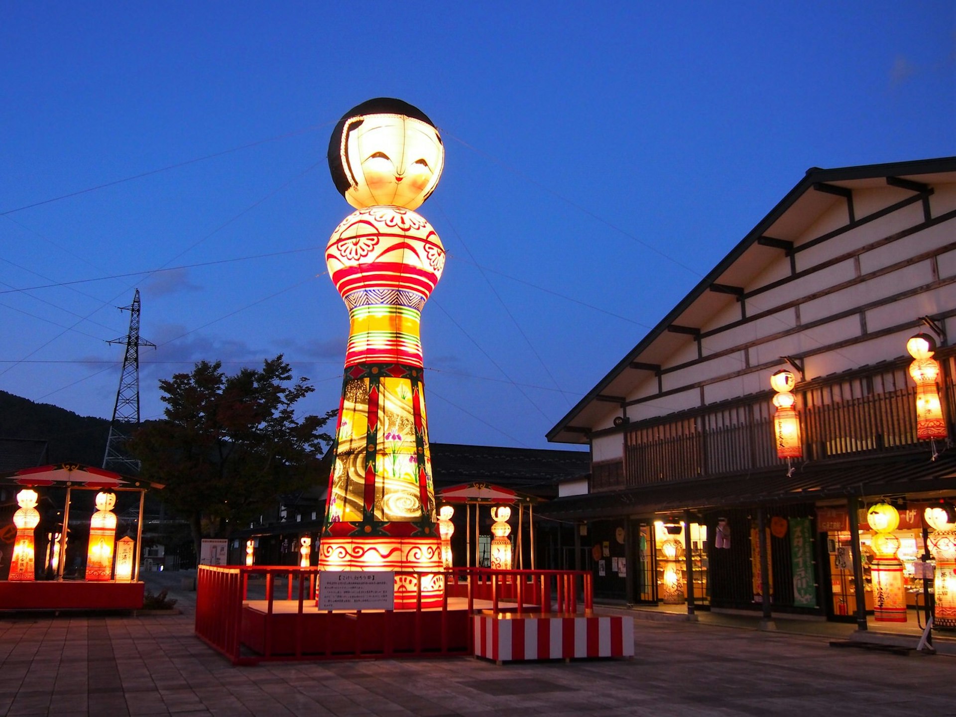 Multiple large and smaller lanterns glow in the dusk in the town of Kuroishi © Manami Okazaki / Lonely Planet