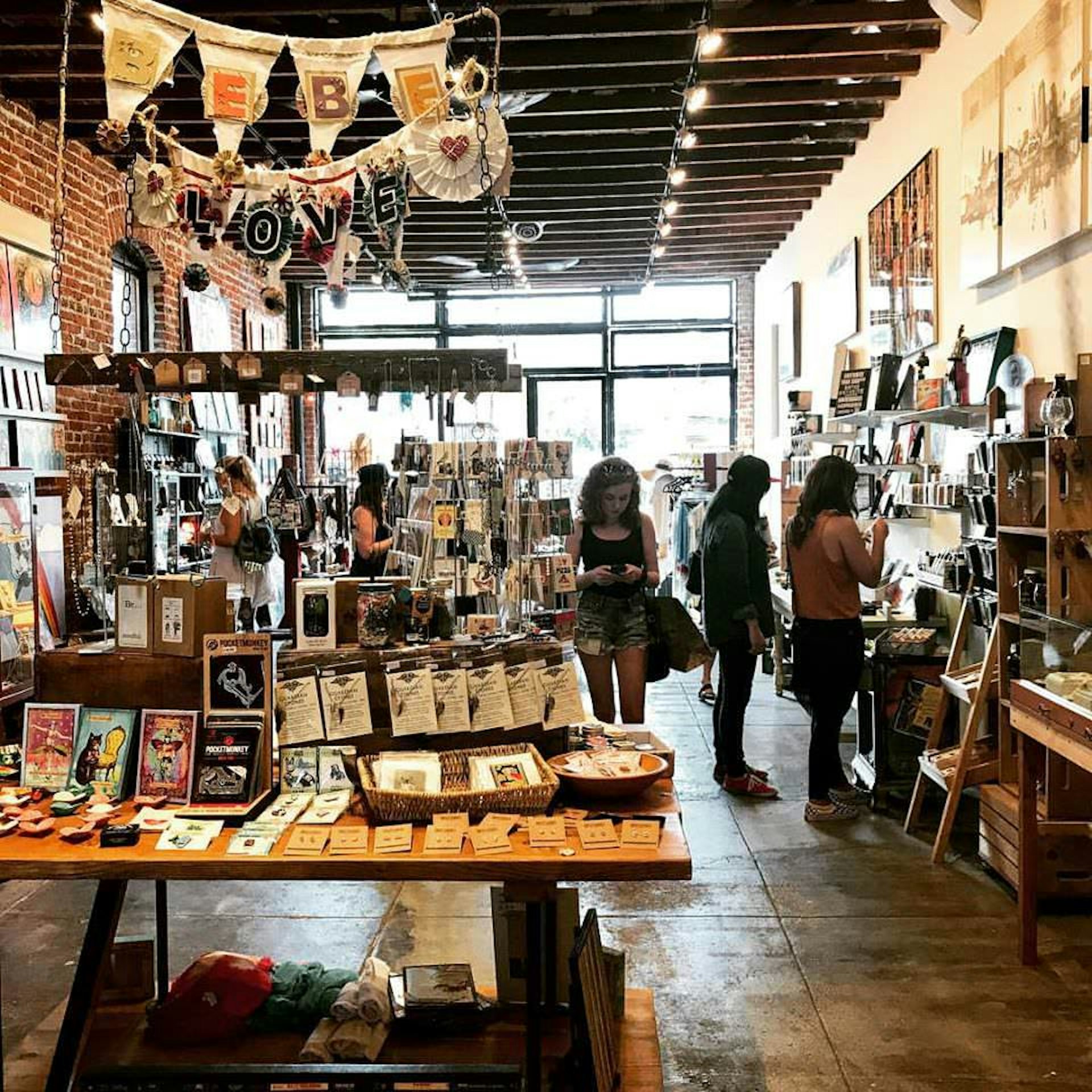 Shoppers browse through a rustic shop, with handmade goods all around