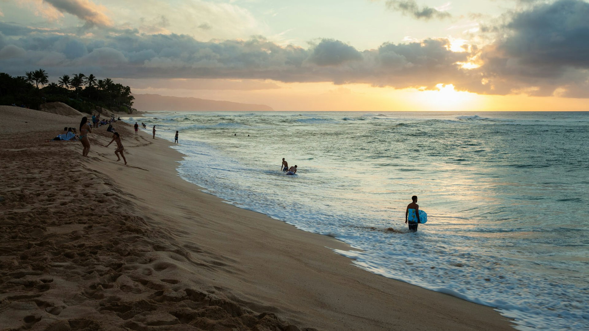 A lone bodyboarder wades into the surf off Oahu, Hawaii © JJM Photography / Shutterstock