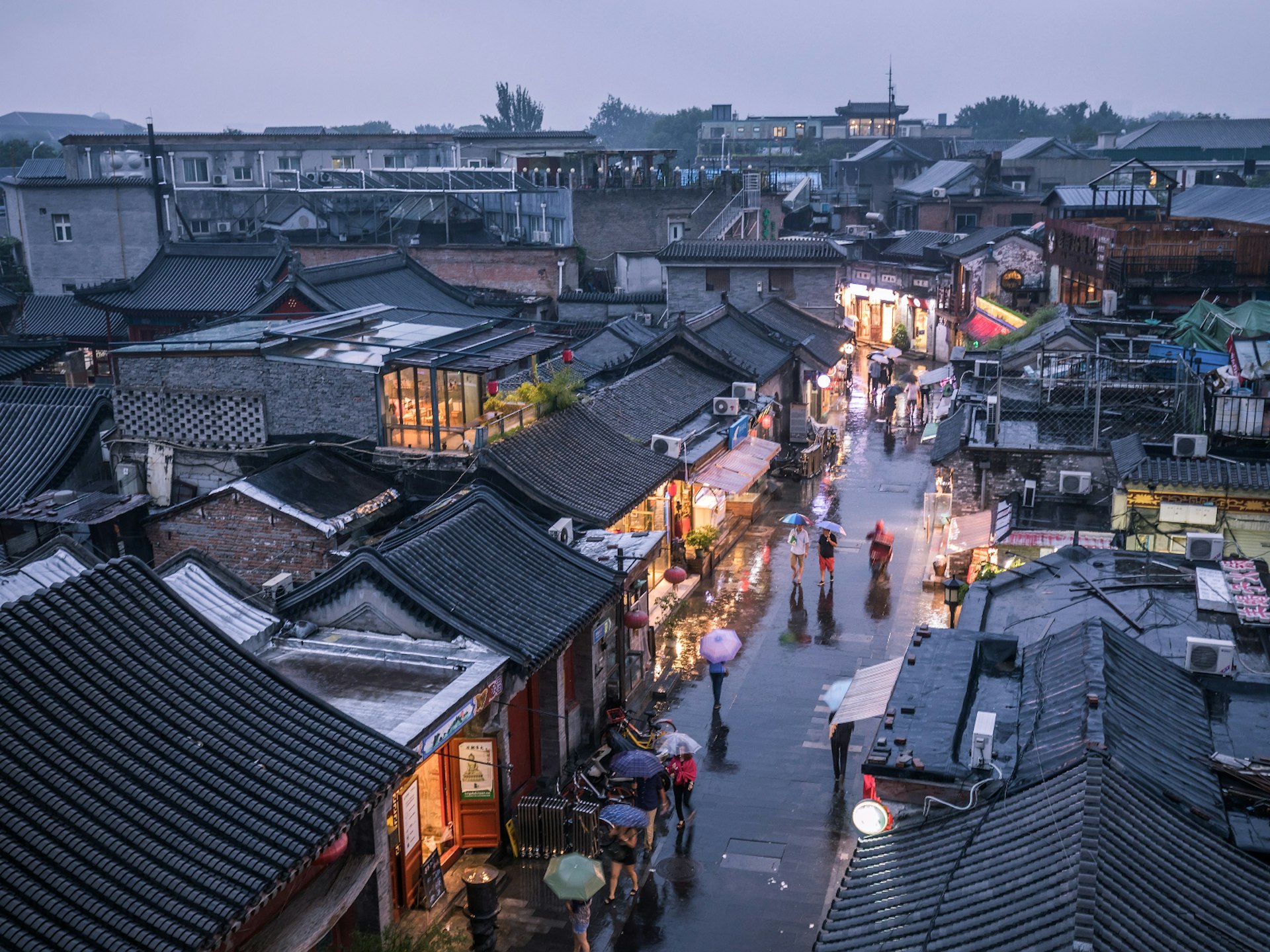 People walking down one of Beijing's historic hutong alleyways 