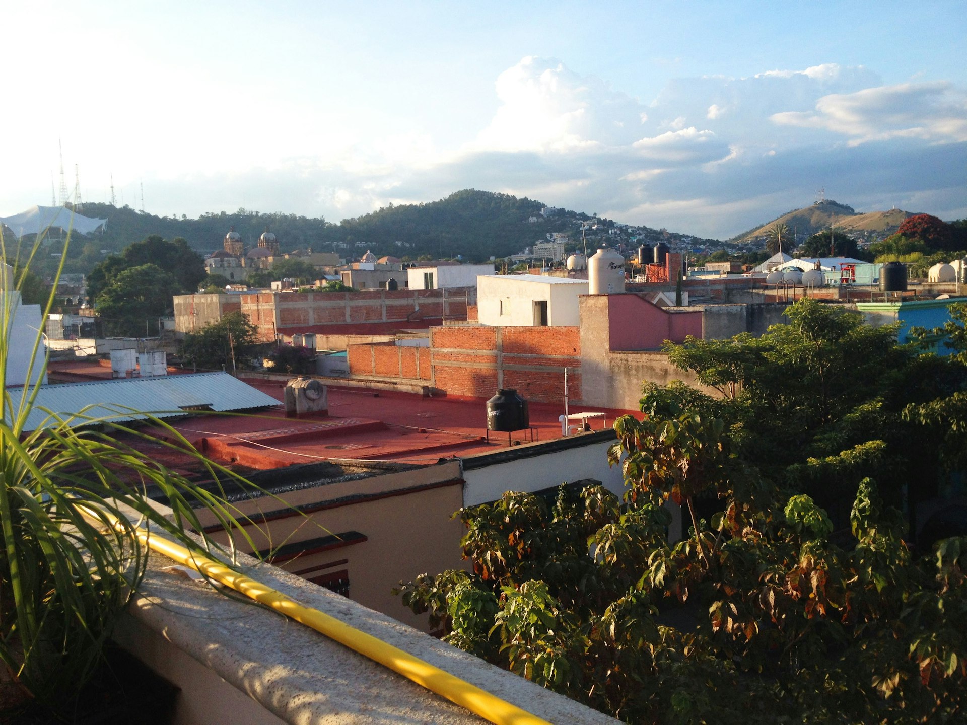the view from the rooftop patio of Comala with the rooftops of Oaxaca and a mountain in the background