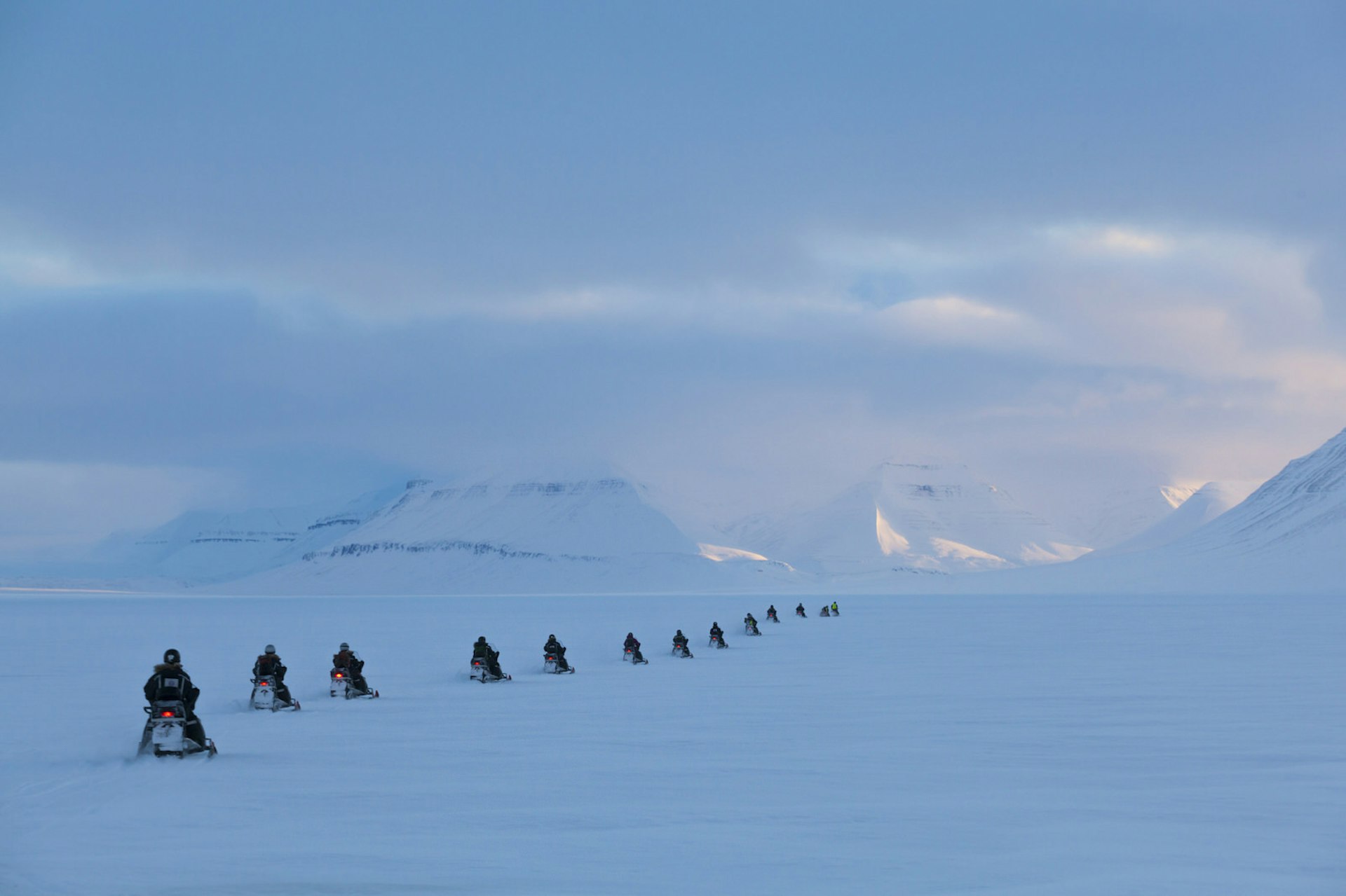 A group of people on snowmobiles exploring Svalbard © Ethan Welty / Getty Images