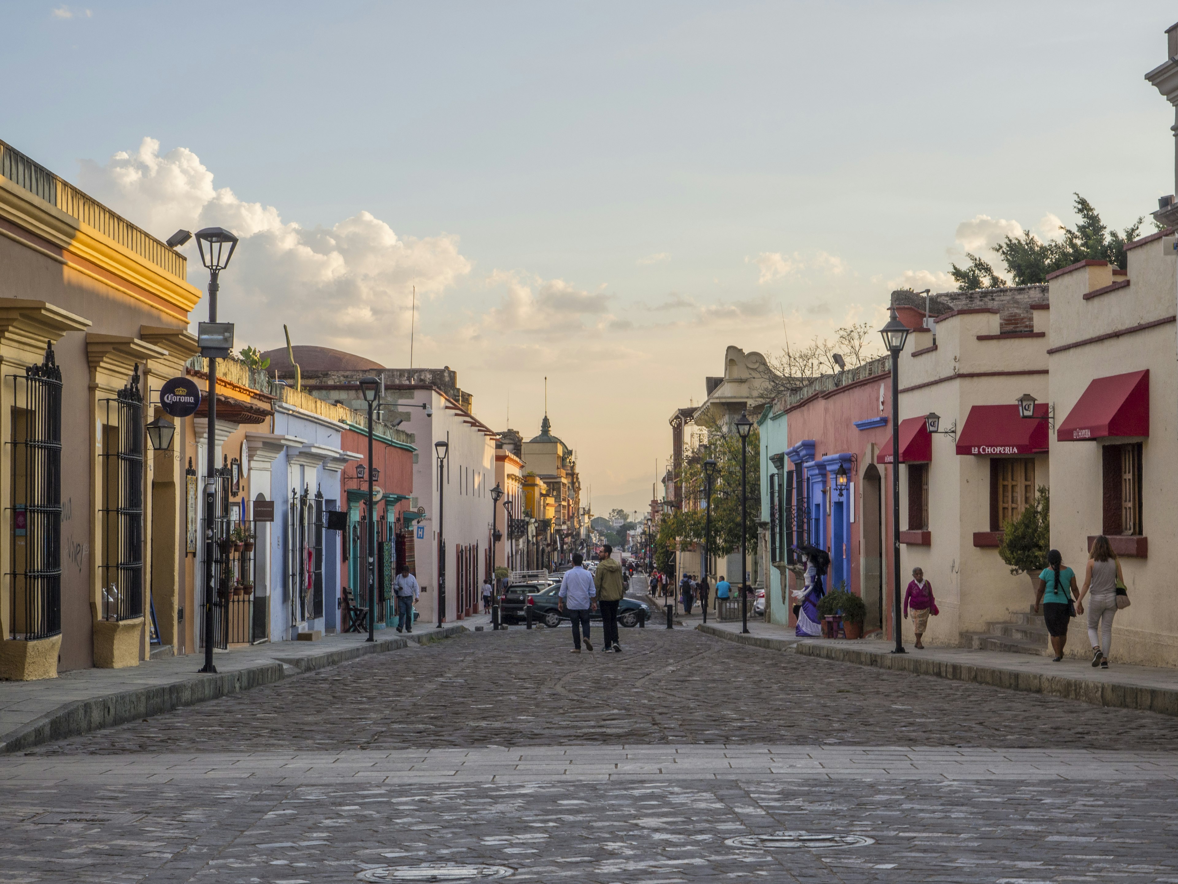 People wander down a cobble stone street lined with colorful colonial buildings in Oaxaca, Mexico © Melissa Kuhnell