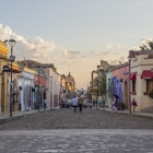 People wander down a cobble stone street lined with colorful colonial buildings in Oaxaca, Mexico © Melissa Kuhnell