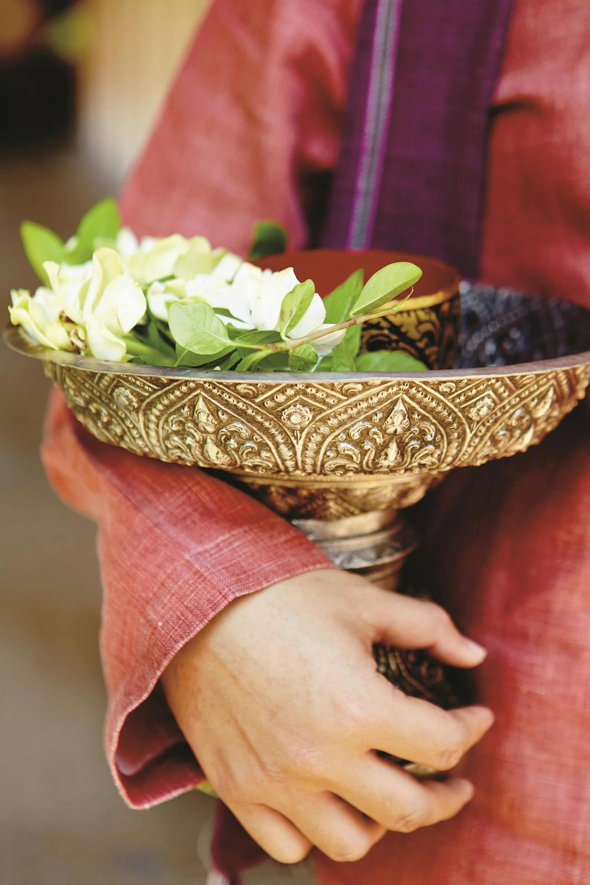 A temple offering of colourful flowers is contained within an ornate bowl © Matt Munro / Lonely Planet