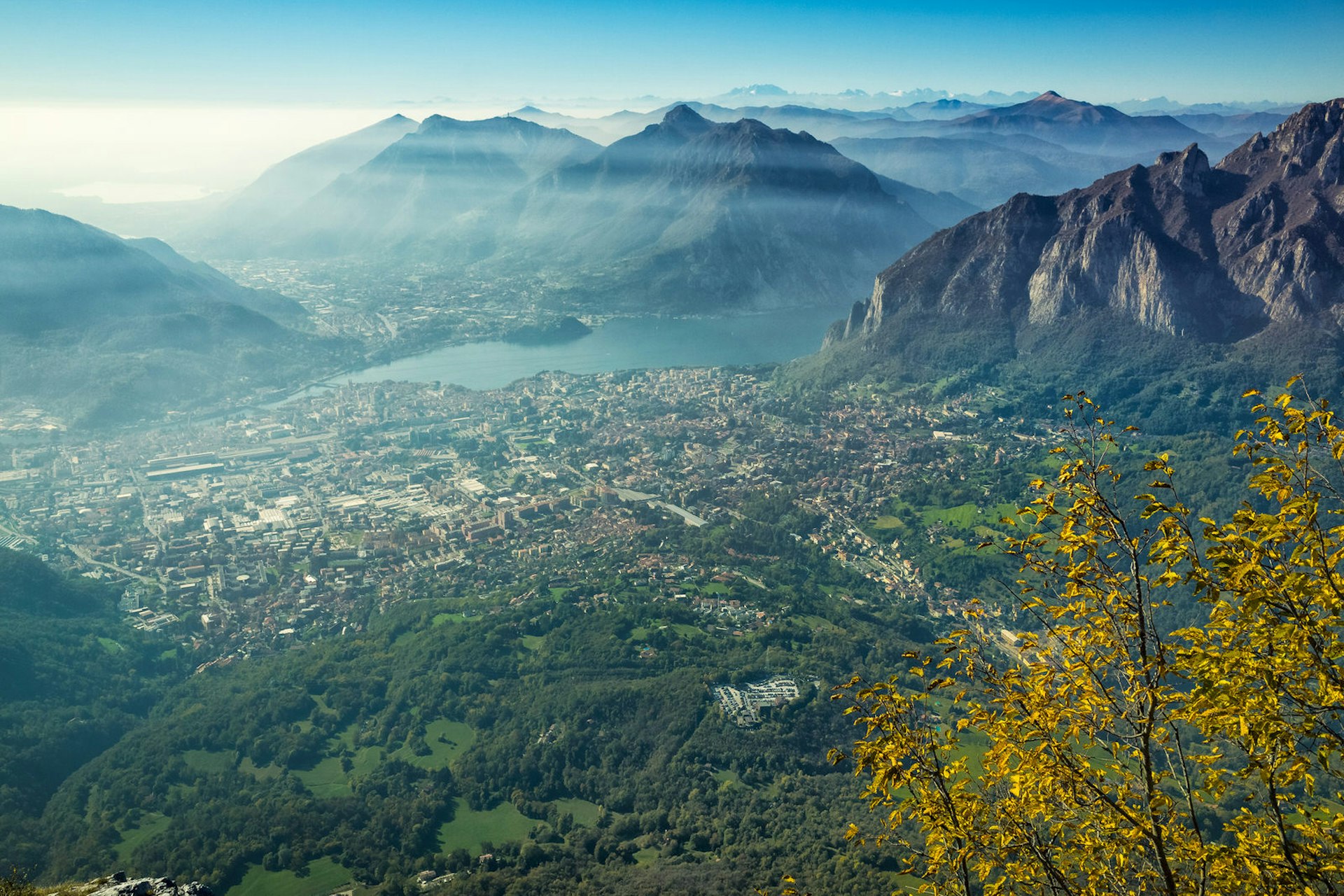 View from a hill towards the town of Lecco and Lake Como, with mountains in the distance