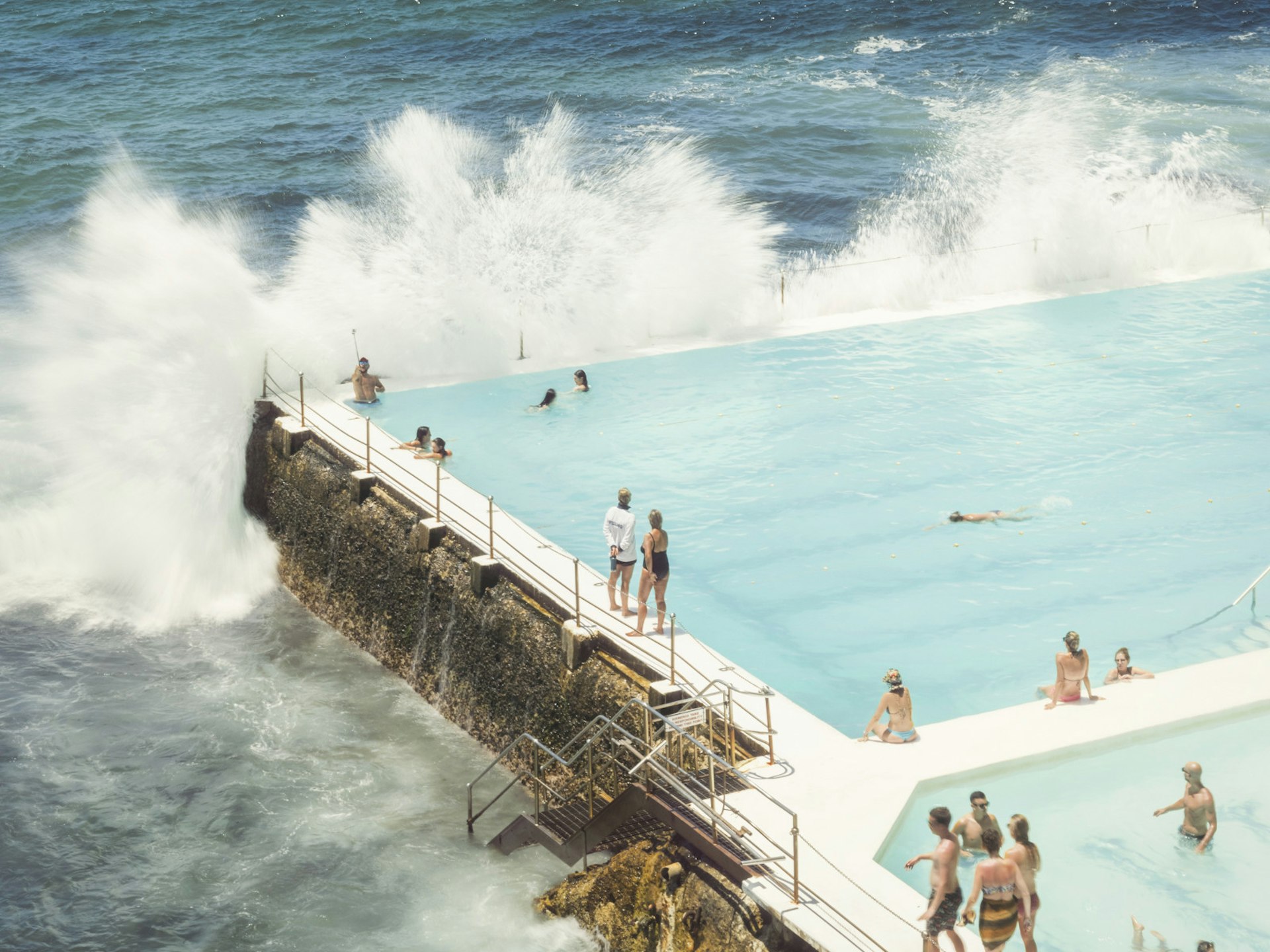 Ocean waves crashing over the saltwater Bondi Baths