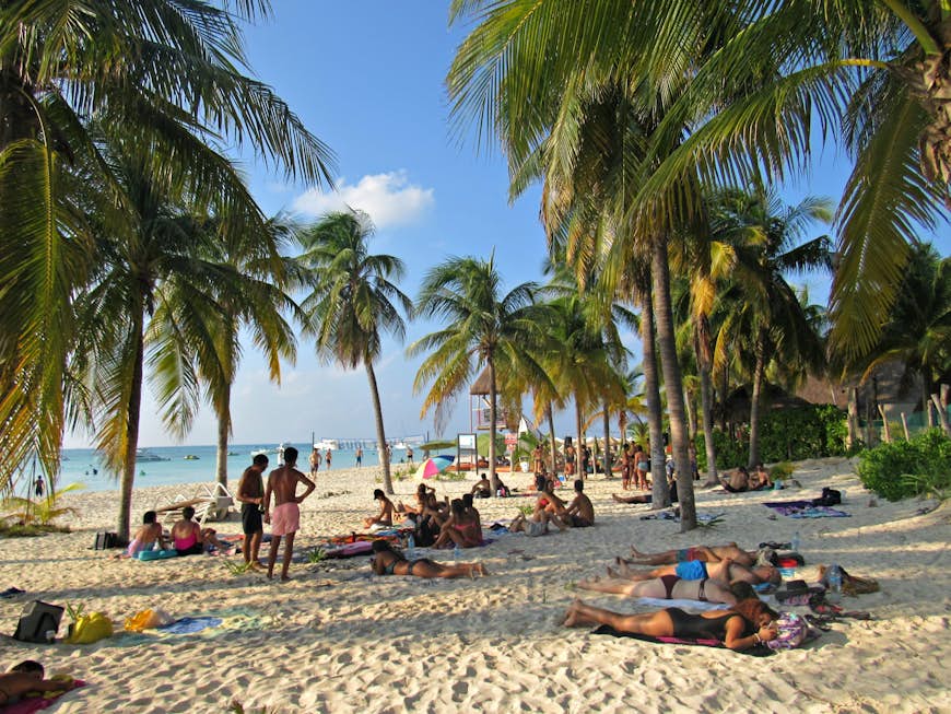 Människor kopplar av under palmträdet på de vita sandstränderna © Laura Winfree / Lonely Planet