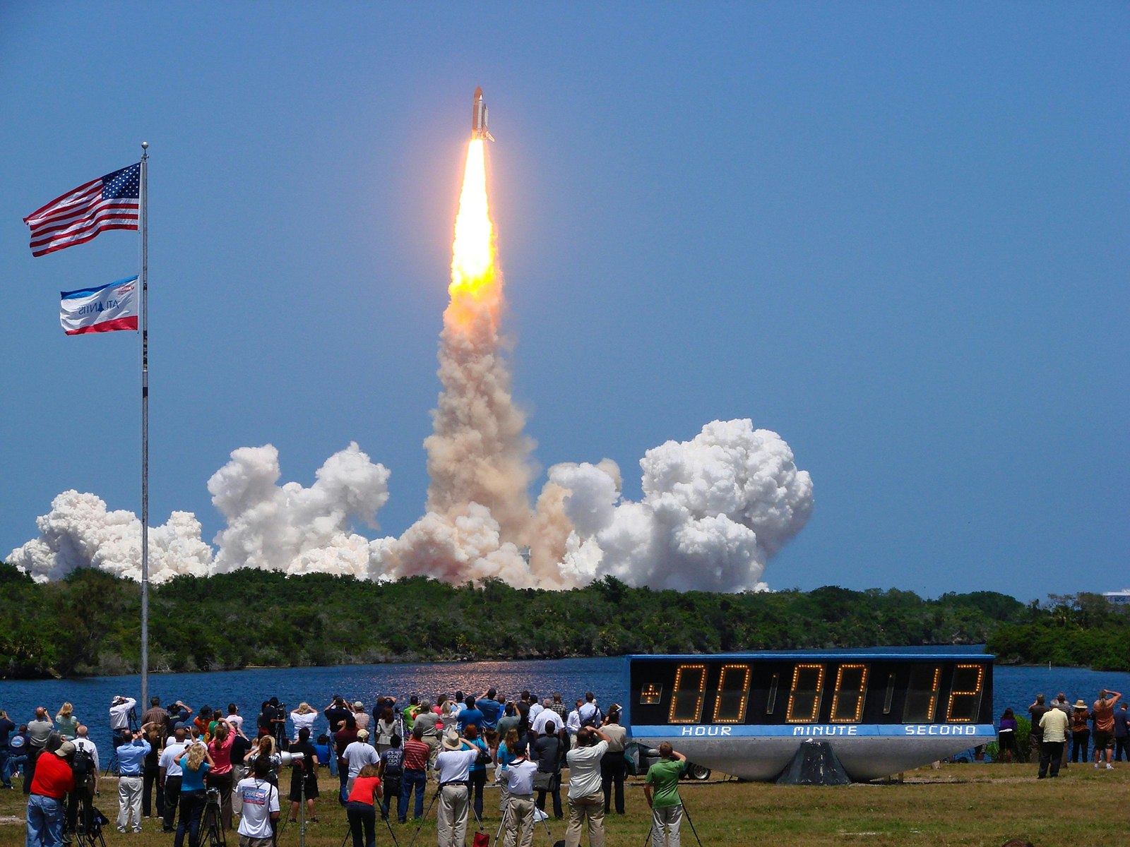 crowd watches as the countdown clock hits zero and the space shuttle Atlantis launches into orbit in 2011; how to experience a rocket launch on Florida's Space Coast