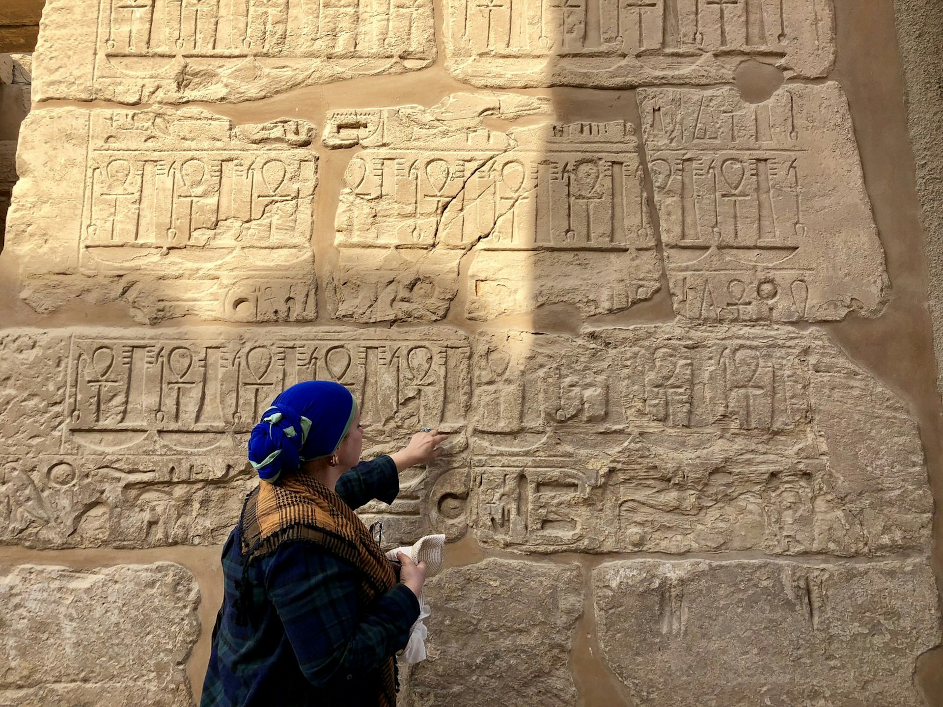 Egyptian guide points out hieroglyphics at Karnak, Luxor, Egypt. Image by Lauren Keith / Lonely Planet