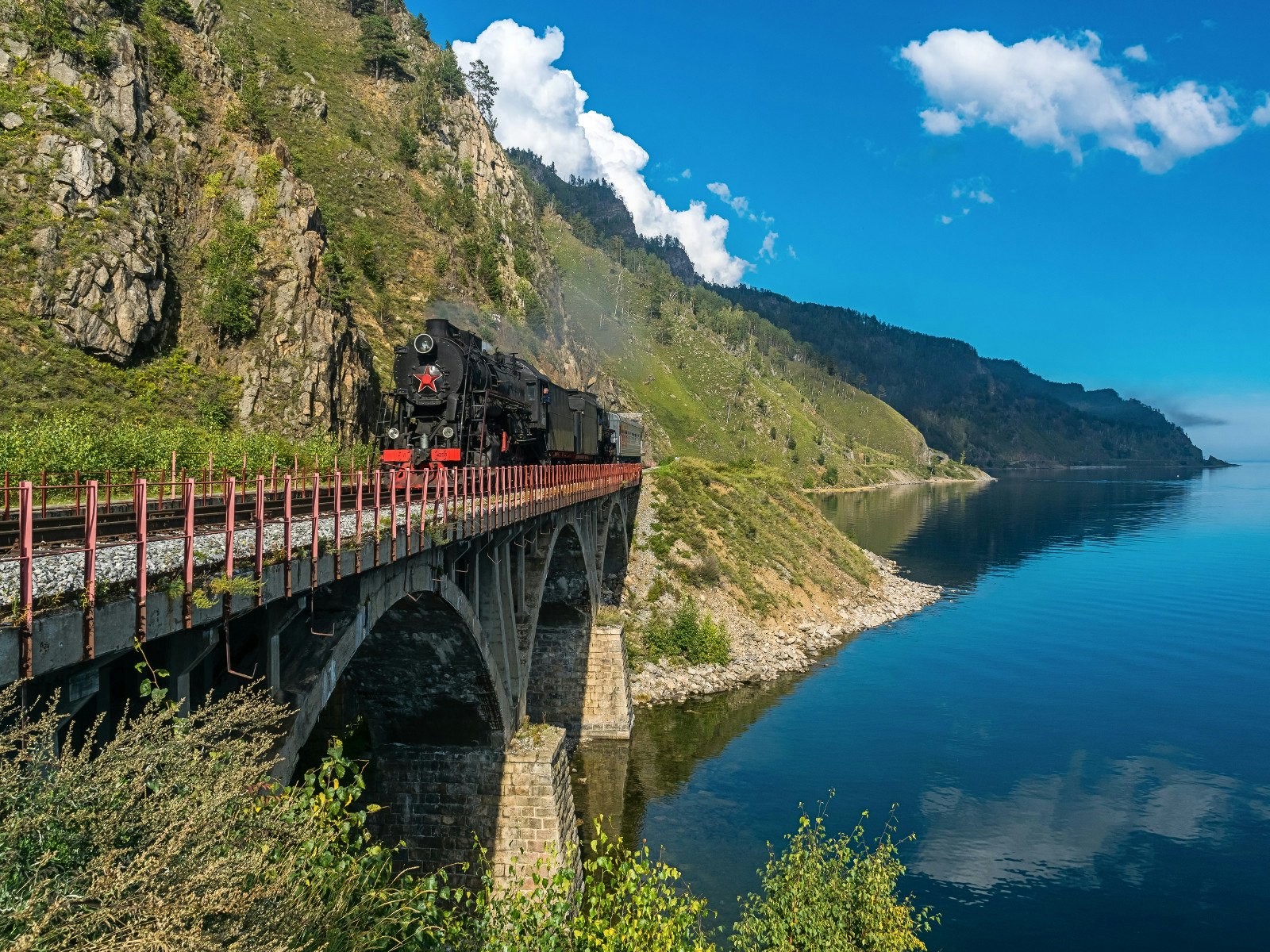 Steam train chugging over a bridge on the Circumbaikal Railway © Tilpunov Mikhail / Shutterstock