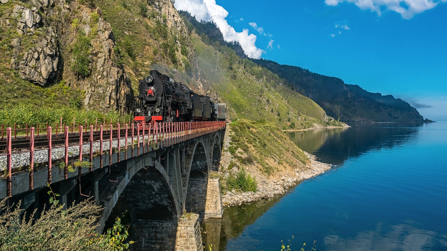 Steam train chugging across a bridge on the Circum-Baikal Railway @ Tilpunov Mikhail / Shutterstock