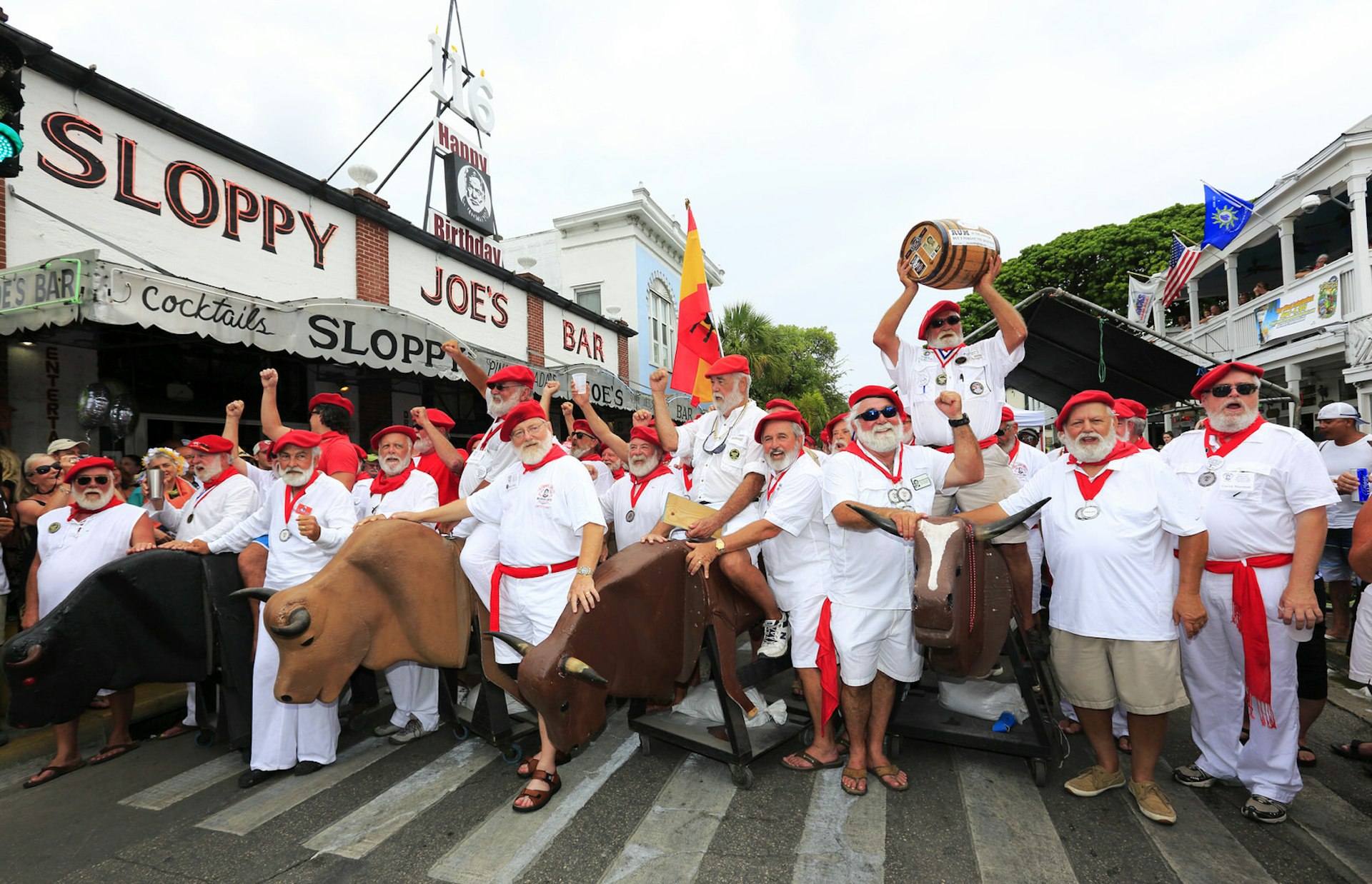 Hemingway look-alikes attending "Running of the Bulls" during the 35th annual Hemingway Days festival on the street of Key West with Sloppy Joe's Bar in the background.