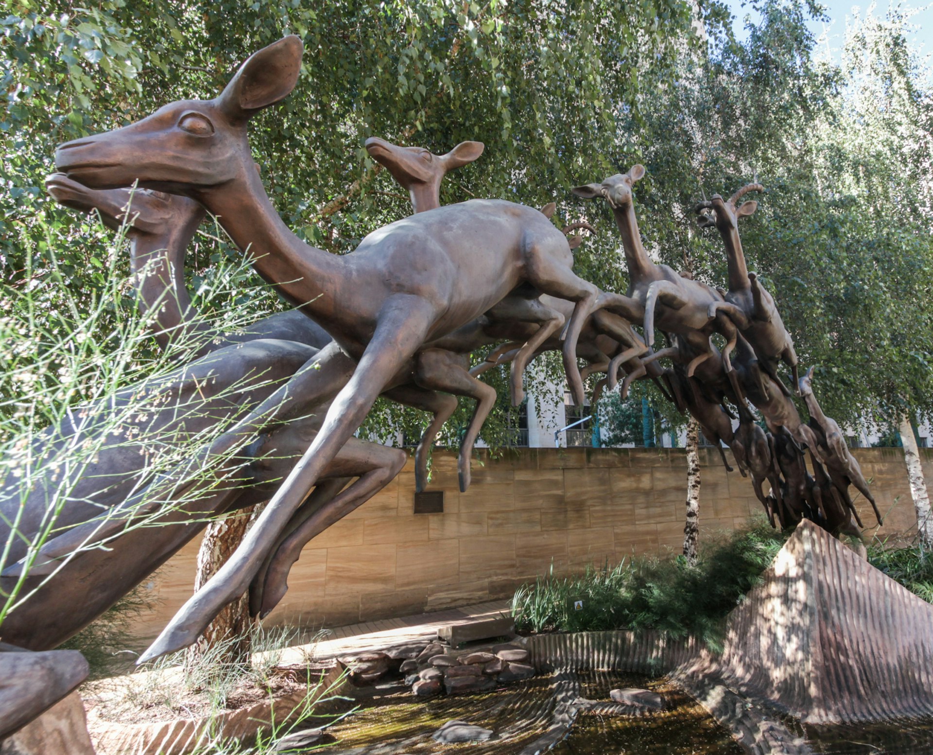 A large bronze statue of leaping impalas, one behind the other. With those at the back leaping, those in the middle flying in the air, and those at the front in the act of landing, the statue forms a large arch © Heather Mason / Lonely Planet