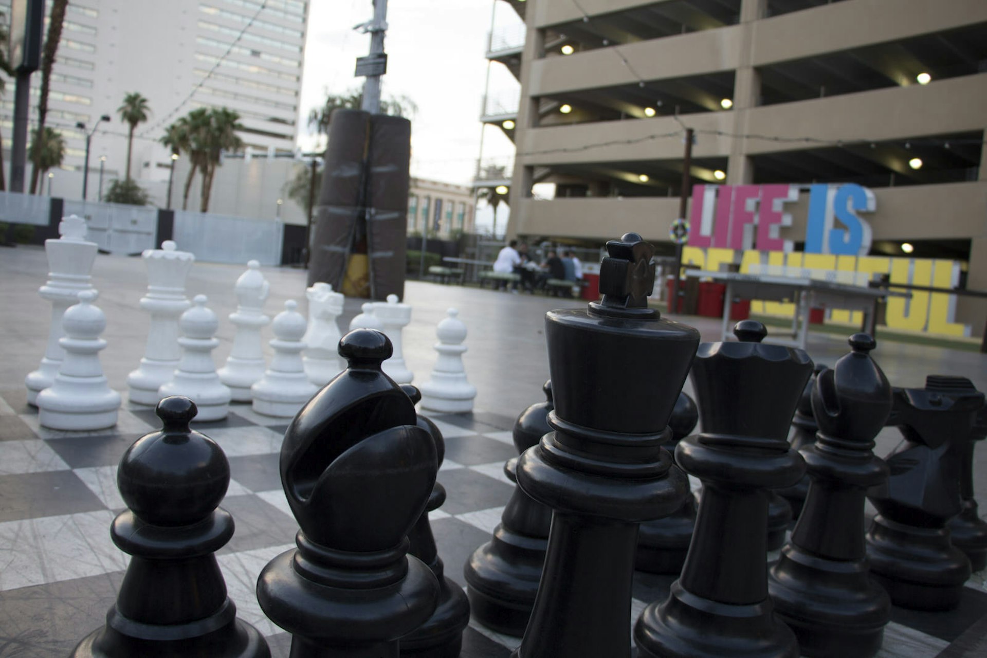 A large chess set, big enough for people to walk around and move the pieces, is seen in the foreground of an outdoor games area in Las Vegas © Greg Thilmont / Lonely Planet