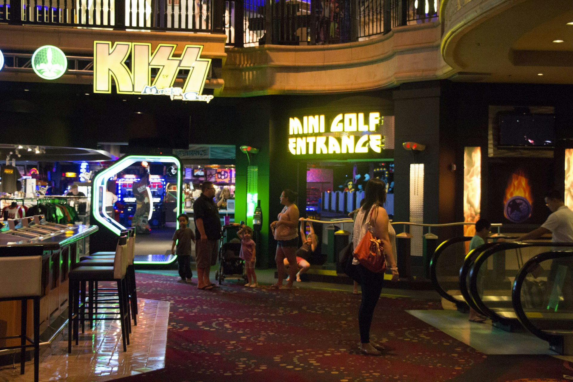The entrance to an indoor mini golf venue is seen, with multi-colored lights all around and the logo of the heavy metal band KISS spelled out in bright light bulbs. © Greg Thilmont / Lonely Planet