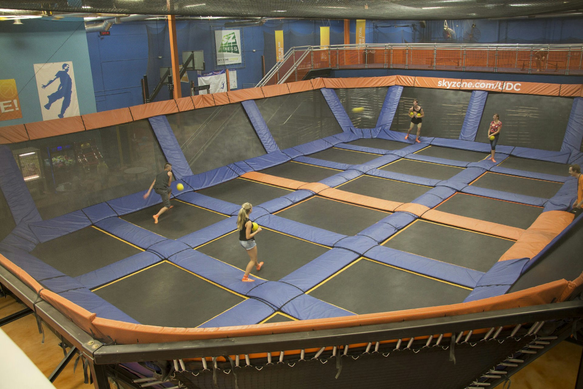 A large arena, made up of padded walls and multiple trampolines as the floor, is shown, with people standing inside and playing dodgeball © Greg Thilmont / Lonely Planet