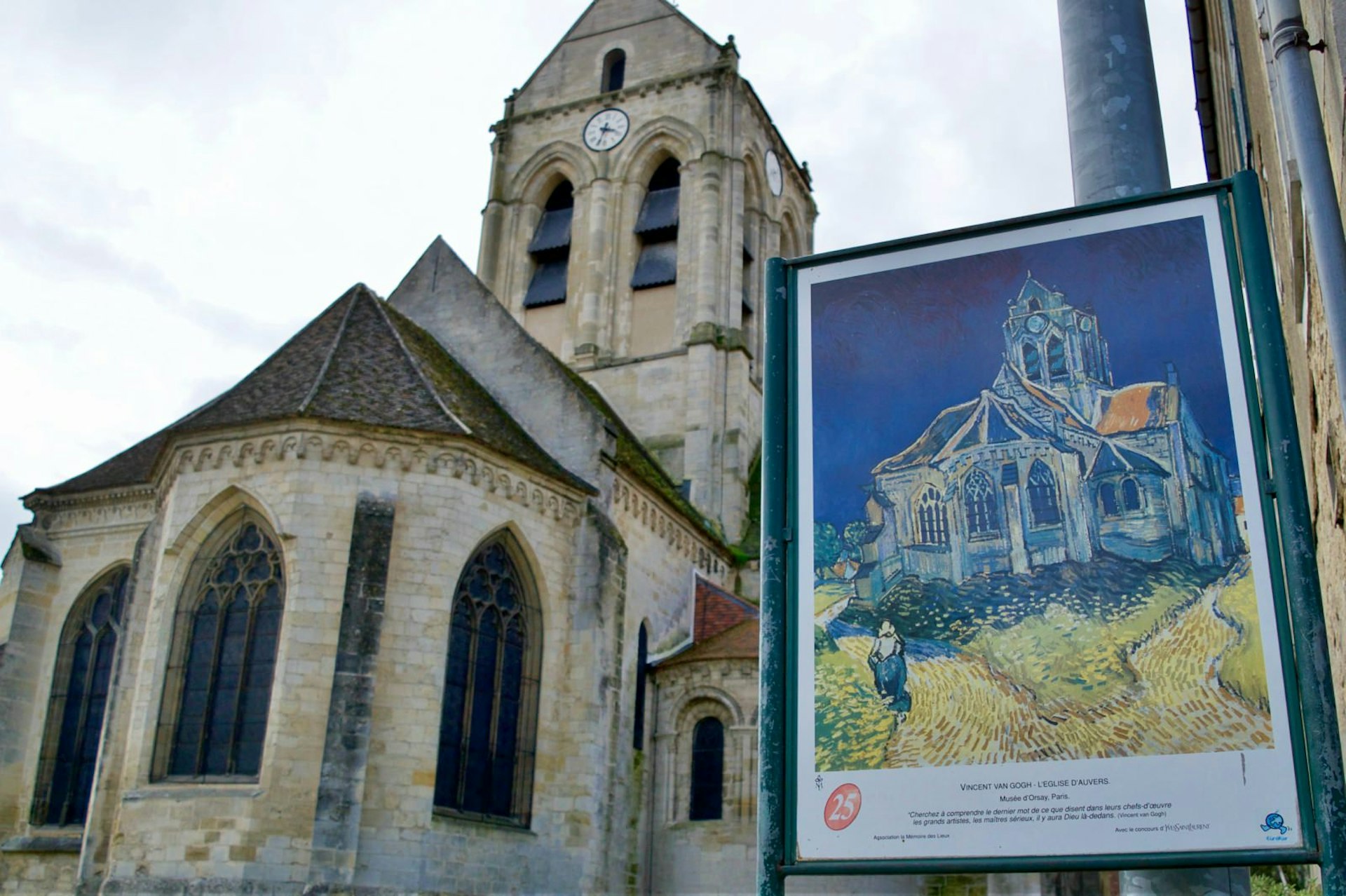 A copy of Van Gogh's Church at Auvers stands next to the cream-bricked chapel itself © Janine Eberle / Lonely Planet