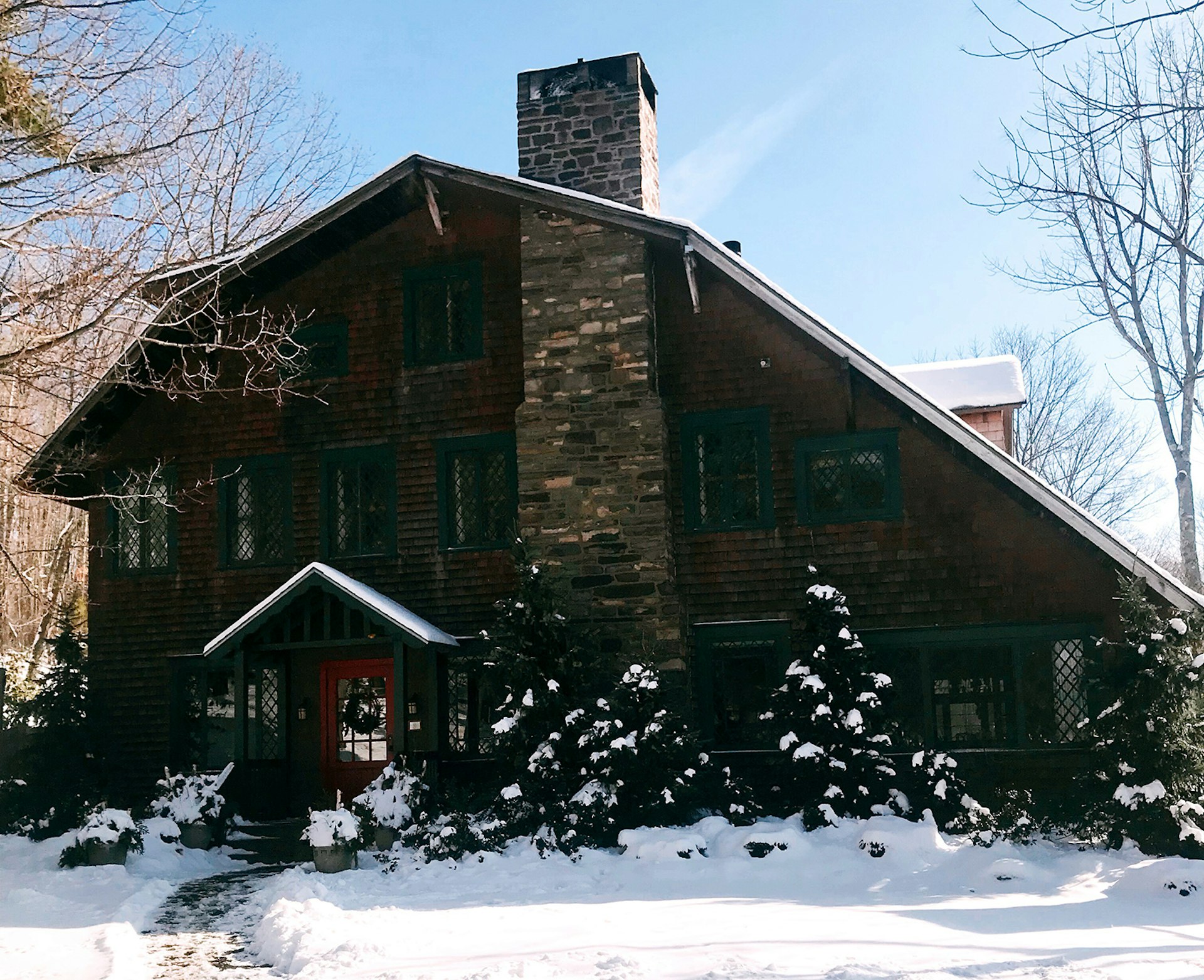 rustikt trävärdshus mot en blå himmel och snöig mark i New York