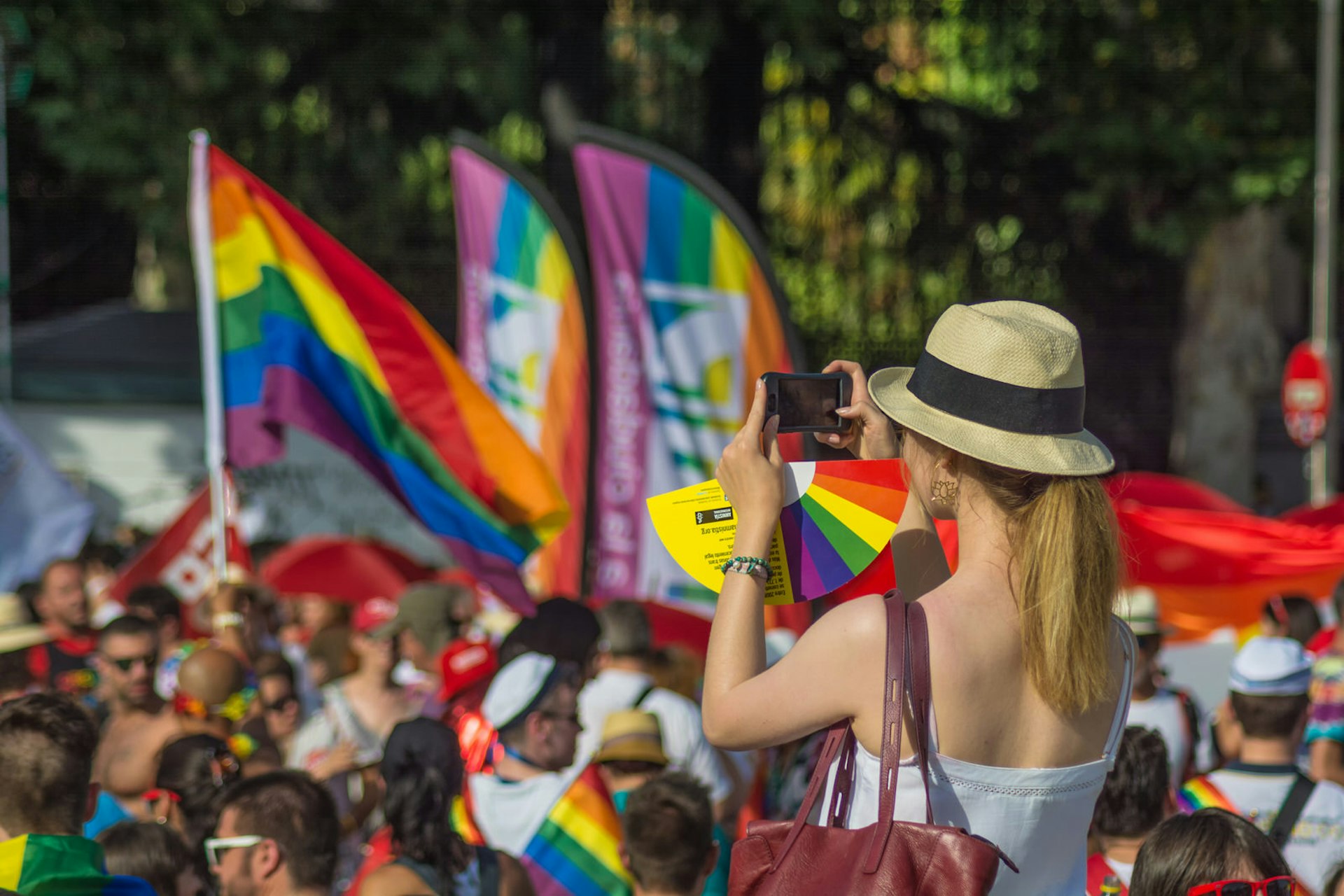 Pride in Europe: A woman takes a photo while sitting on someone's shoulders at Madrid Pride © elRoce / Shutterstock