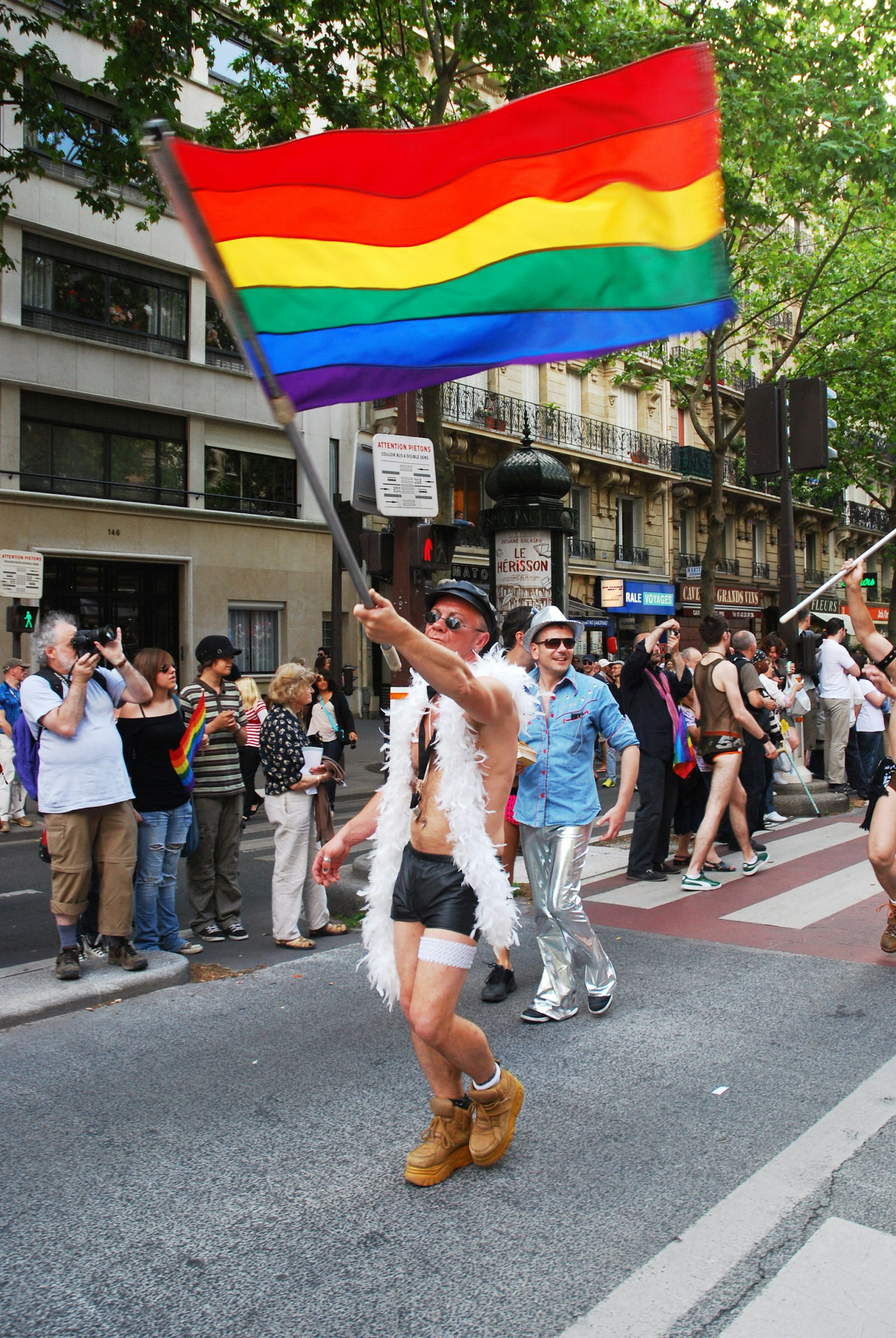 Pride in Europe: A Pride festival goer walks the streets of Paris with a rainbow flag © Olga Besnard / Shutterstock