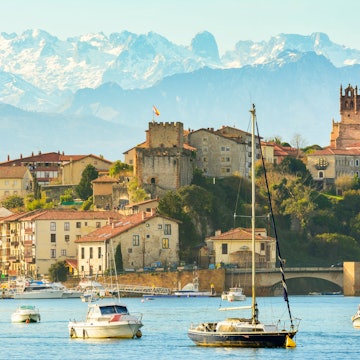 San Vicente de la Barquera, with the snow-capped Picos de Europa behind it © Jon Chica / Shutterstock