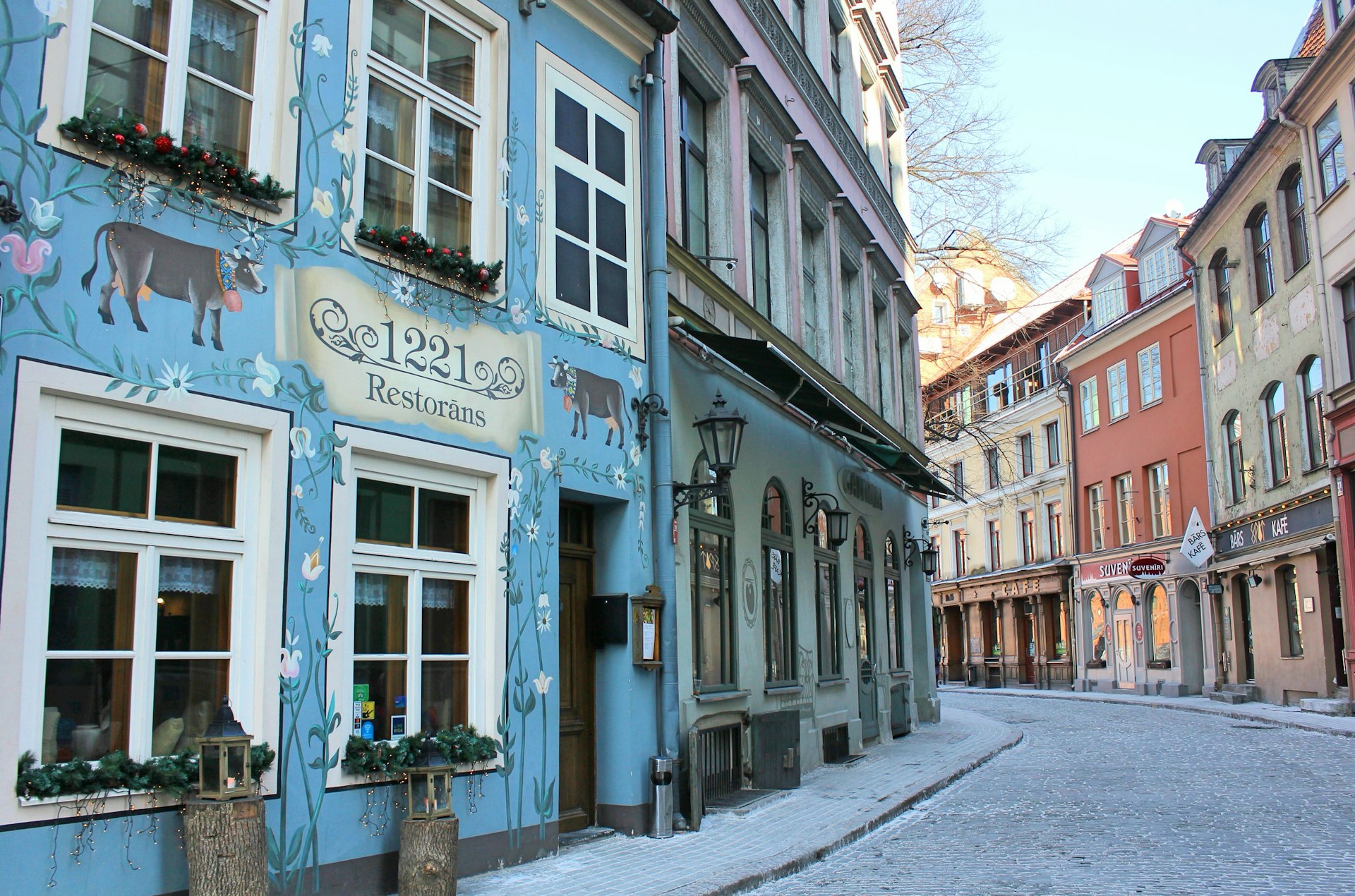 View of the colourful facades of the buildings of pretty Jauniela St, Rīga, which is a winding, cobblestone lane © Caroline Hadamitzky / Lonely Planet