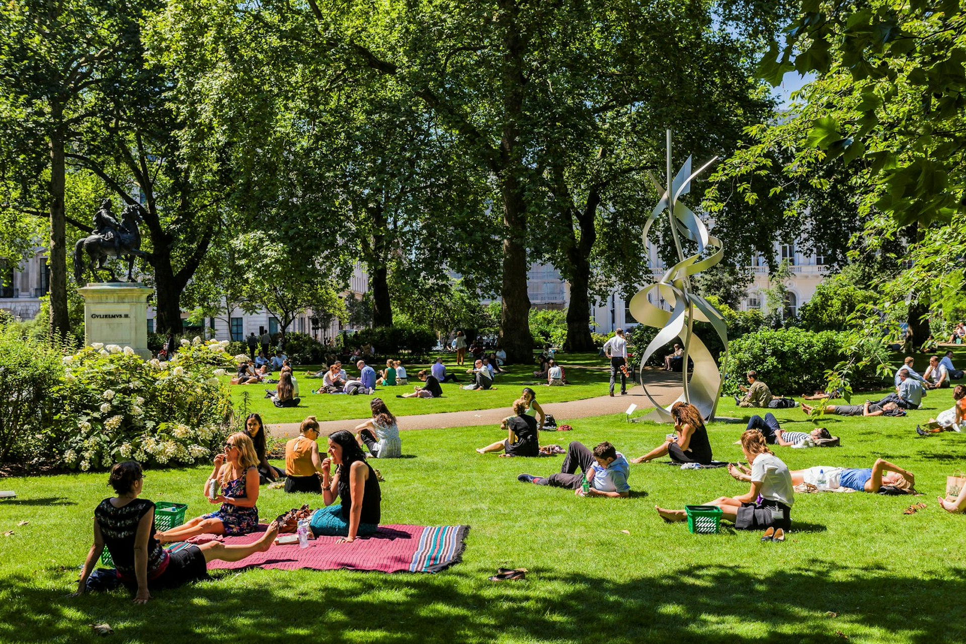 People picnicking in a park in London in sunny weather