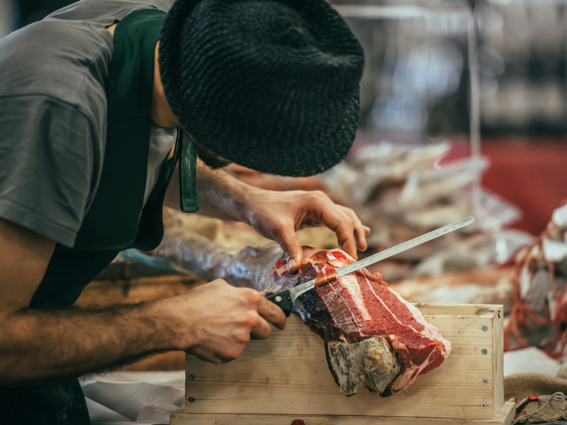 A man slicing dry-cured parma ham