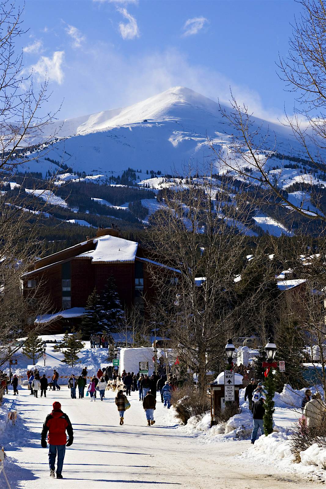 Features - USA, Colorado, Breckenridge, people walking on snow covered street, elevated view A small, snow covered mining town is shown with the backdrop of a stunning and huge mountain © Wesley Hitt / Getty Images