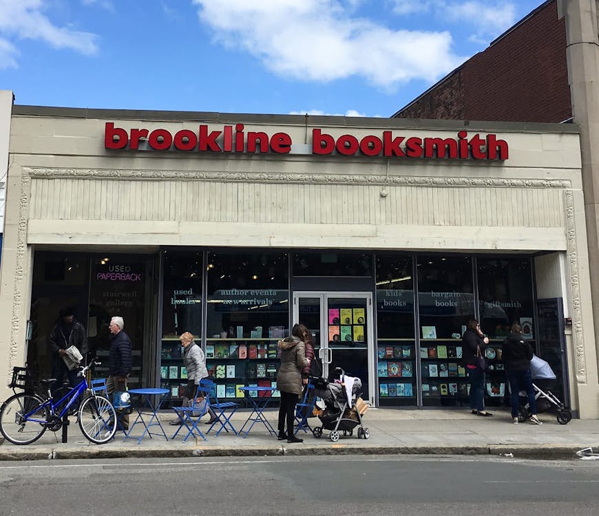 facade of bookstore in strip mall with pedestrians walking past